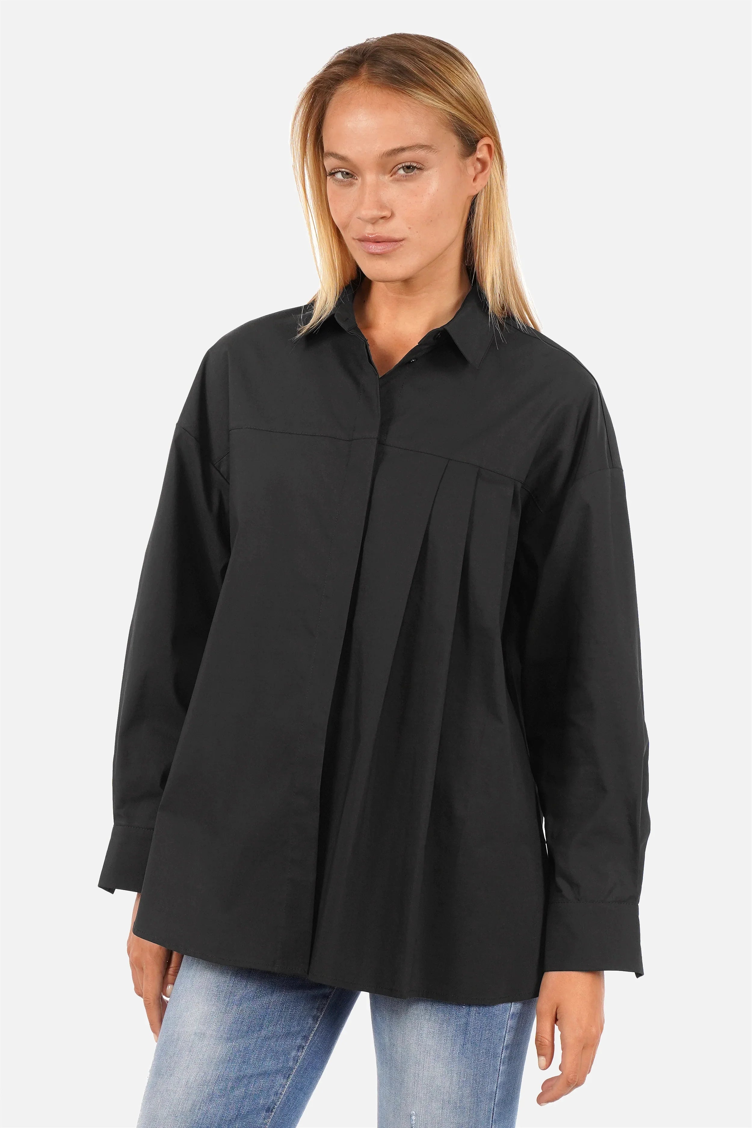 Damen trägt entspannte NEAH Relaxed Bluse aus weichem Popeline mit asymmetrischem Faltendetail und verdeckter Knopfleiste