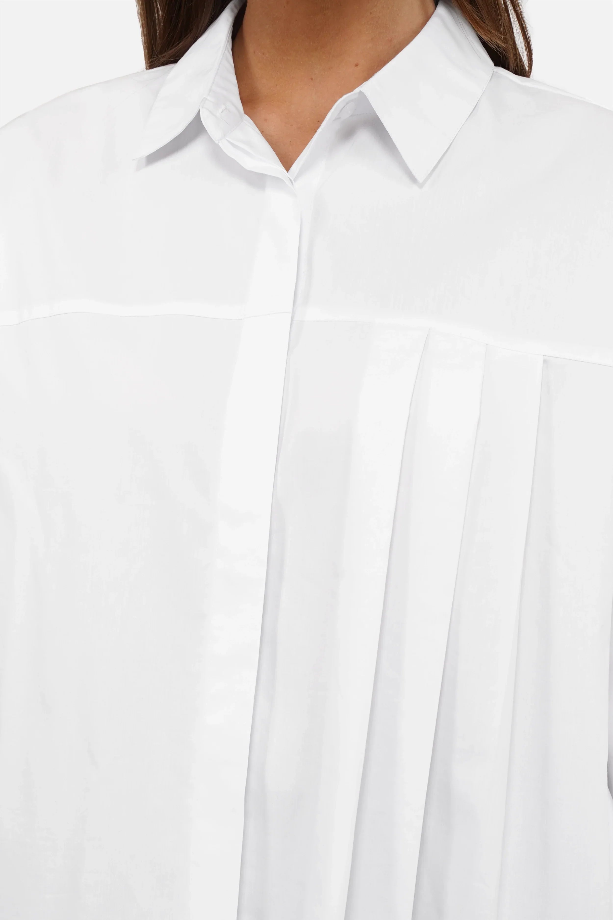 Damenmodell trägt entspannte NEAH Relaxed Bluse aus weicher Popeline mit asymmetrischem Faltendetail und verdeckter Knopfleiste