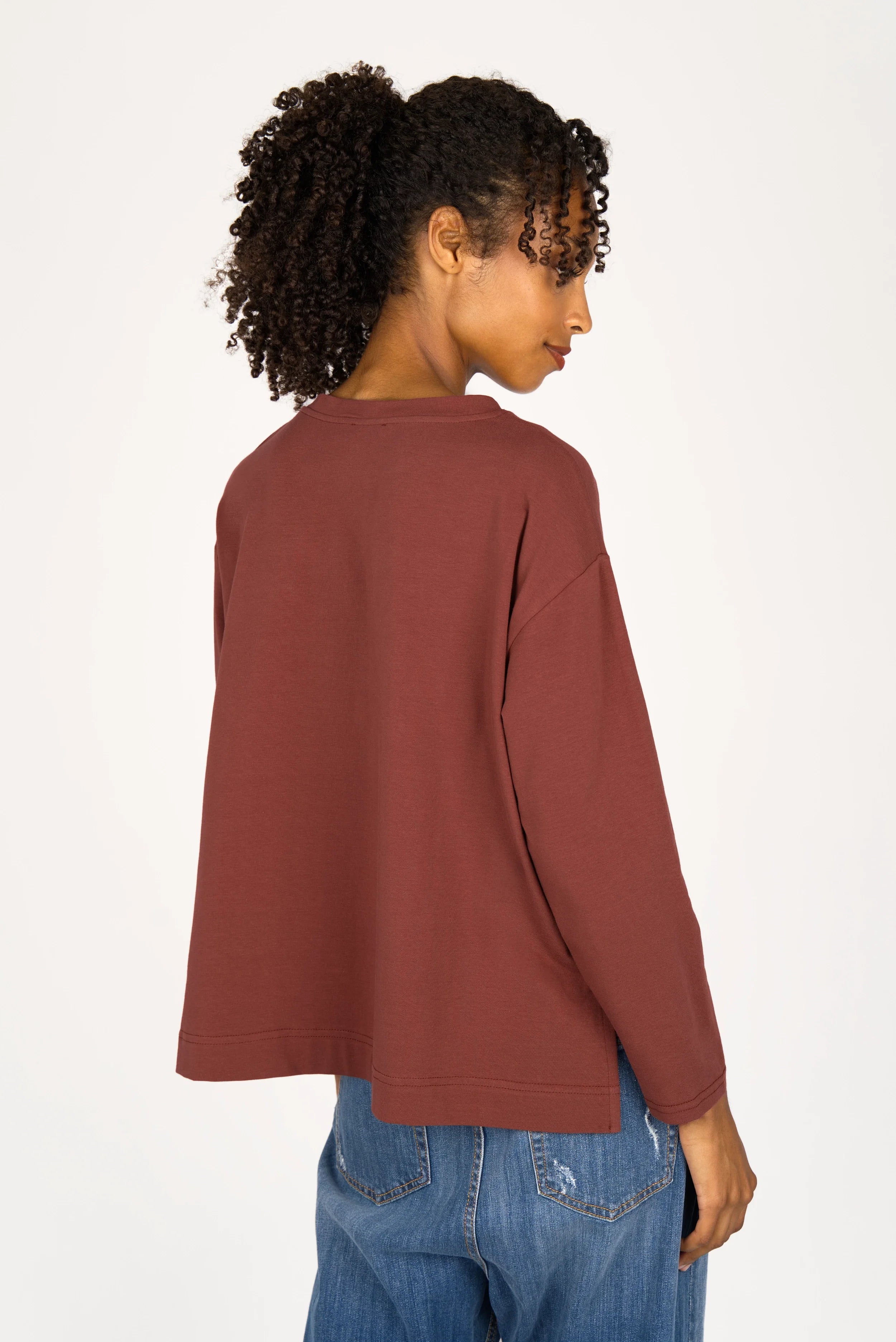 Woman wearing brown NITI.K Langarm Shirt with long sleeves and relaxed fit, shown from the back
