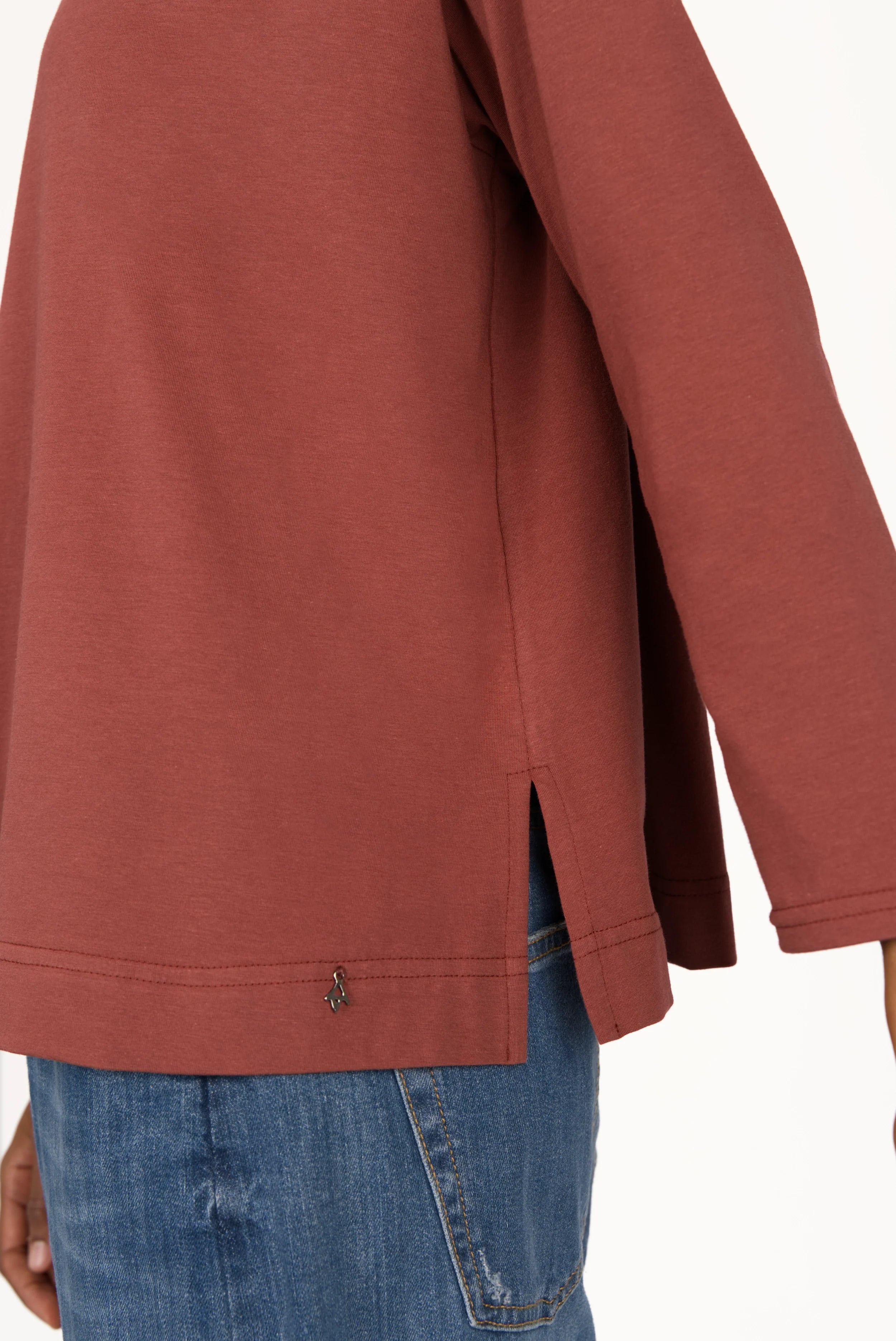 NITI.K Langarm Shirt in rust color with long sleeves, relaxed fit, side slits, and round neckline made from soft stretchy cotton jersey