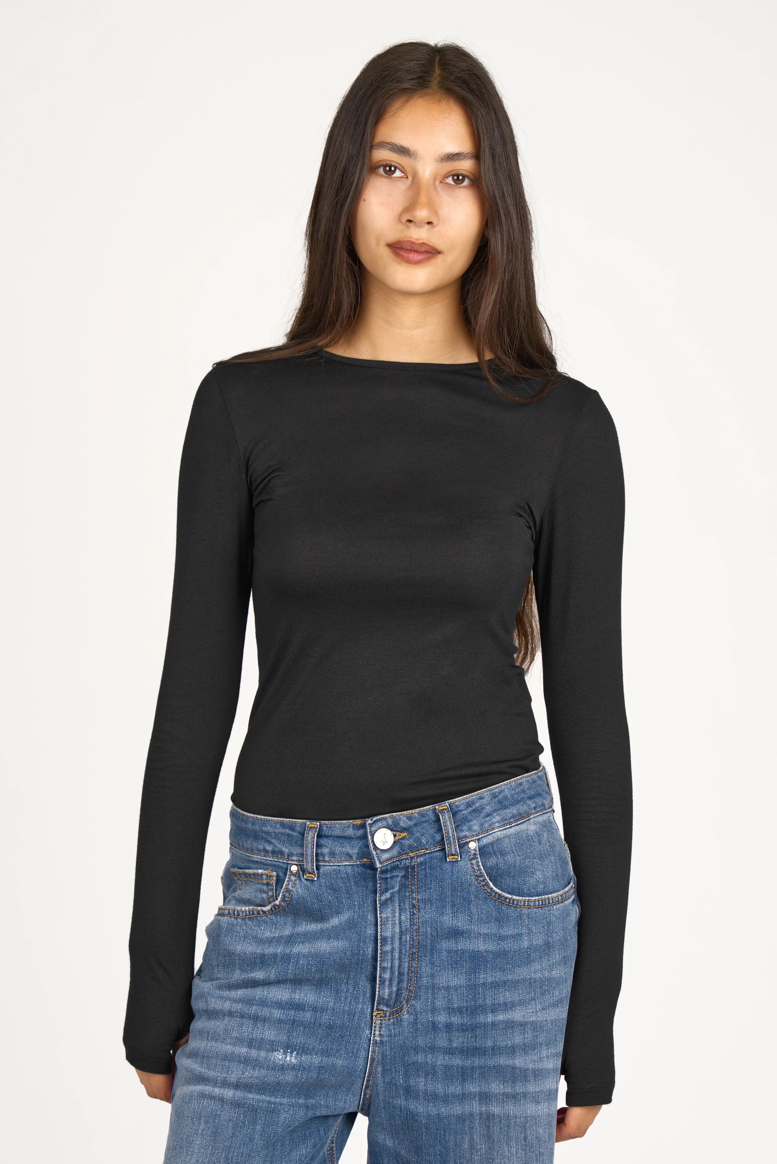 Woman wearing black NJELI Longsleeve with round neckline and thumbhole sleeves paired with blue jeans