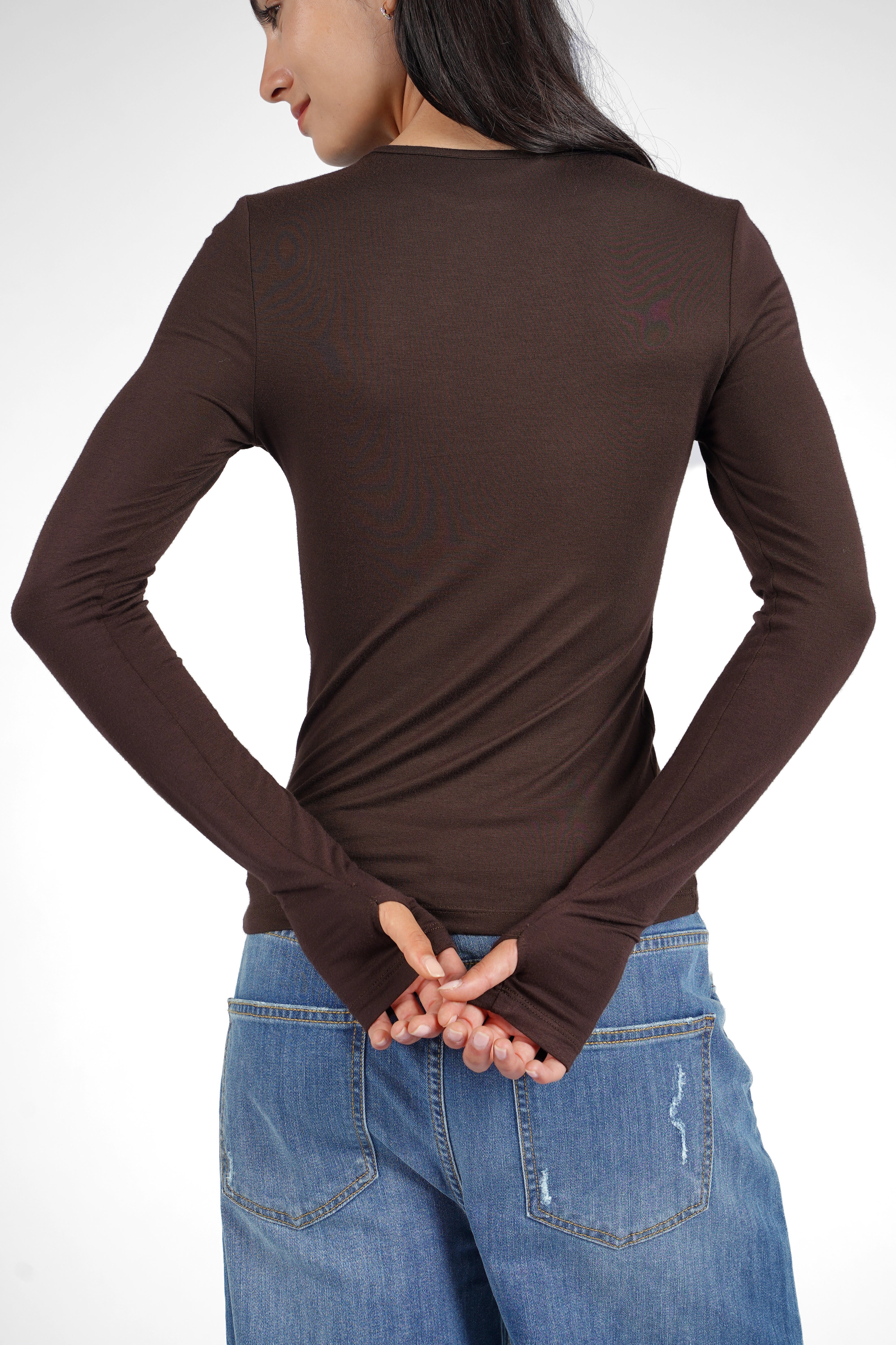 Slim fit NJELI Longsleeve in brown with round neckline and extra-long sleeves featuring thumb holes worn with blue jeans from the back