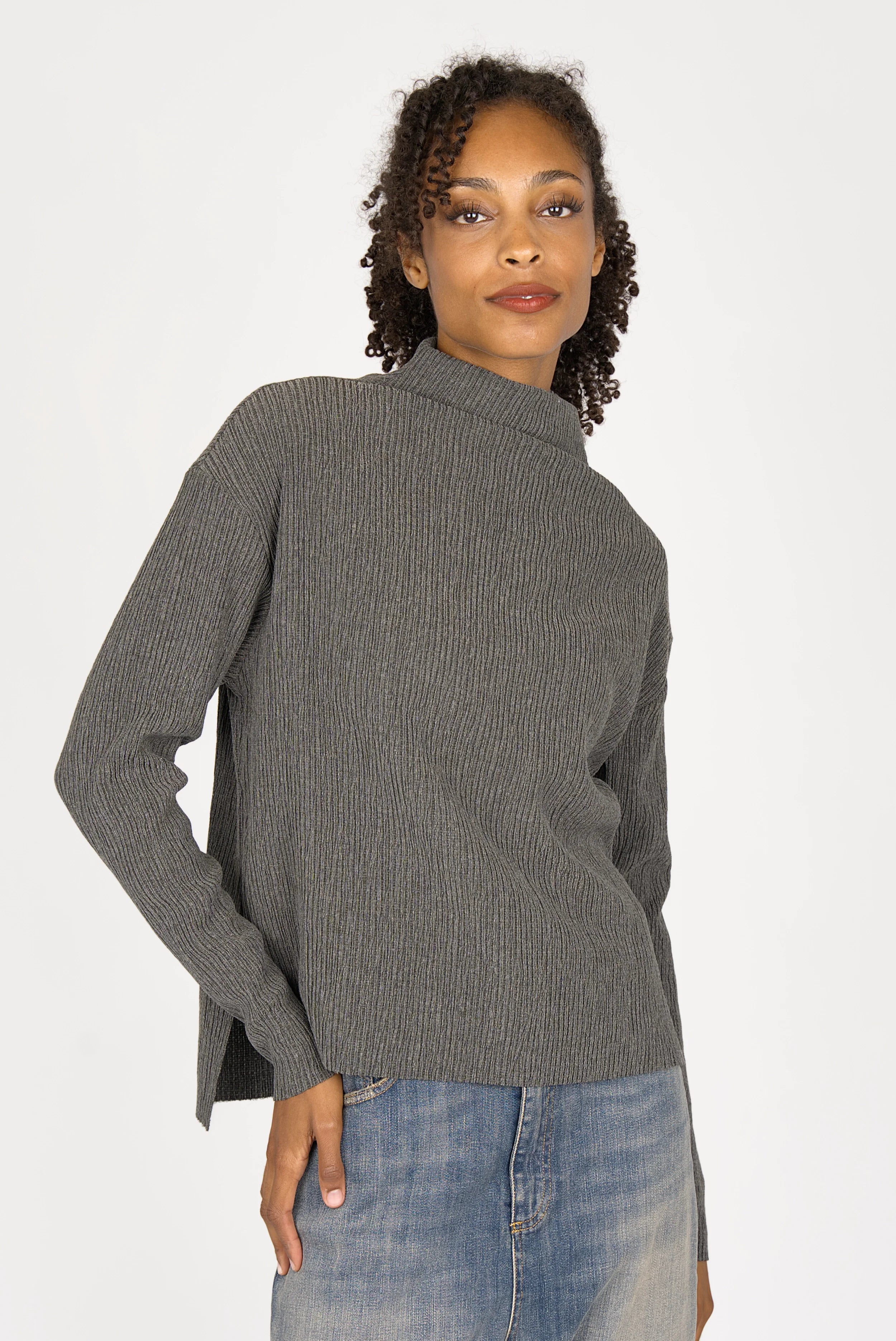 Woman wearing grey NORELI Longsleeve with mock neck and side slits, paired with blue jeans