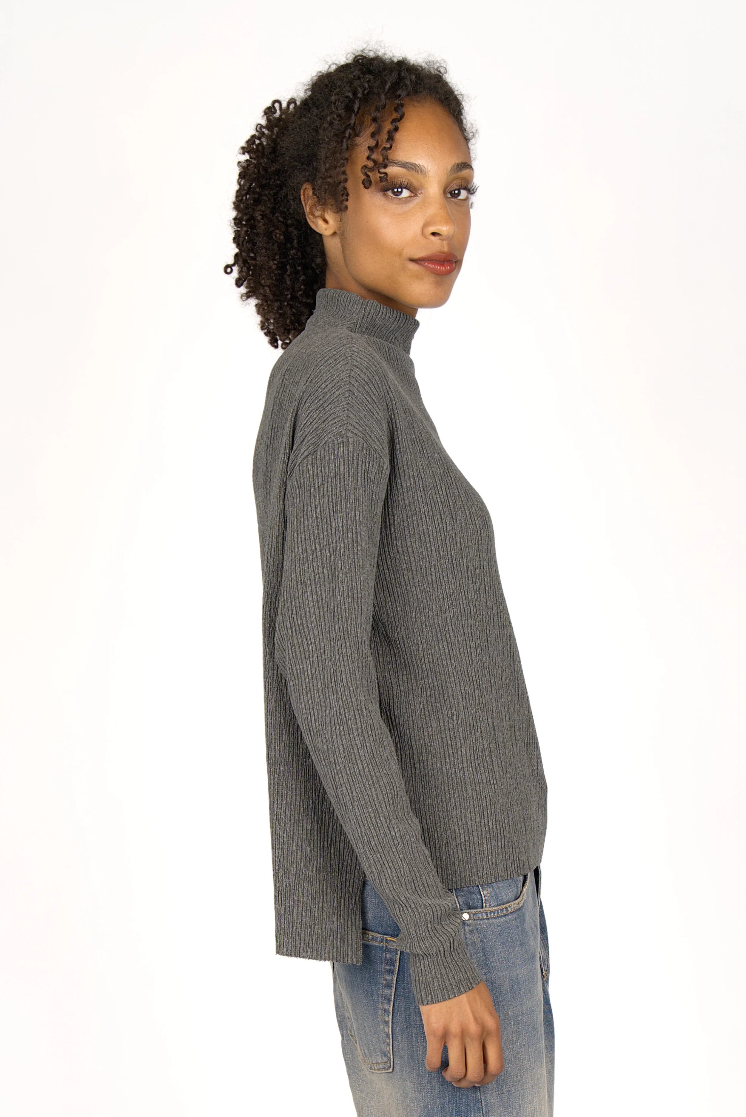 Woman wearing grey NORELI Longsleeve with mock neck and pleated crepe jersey fabric, side slits and extended back hem