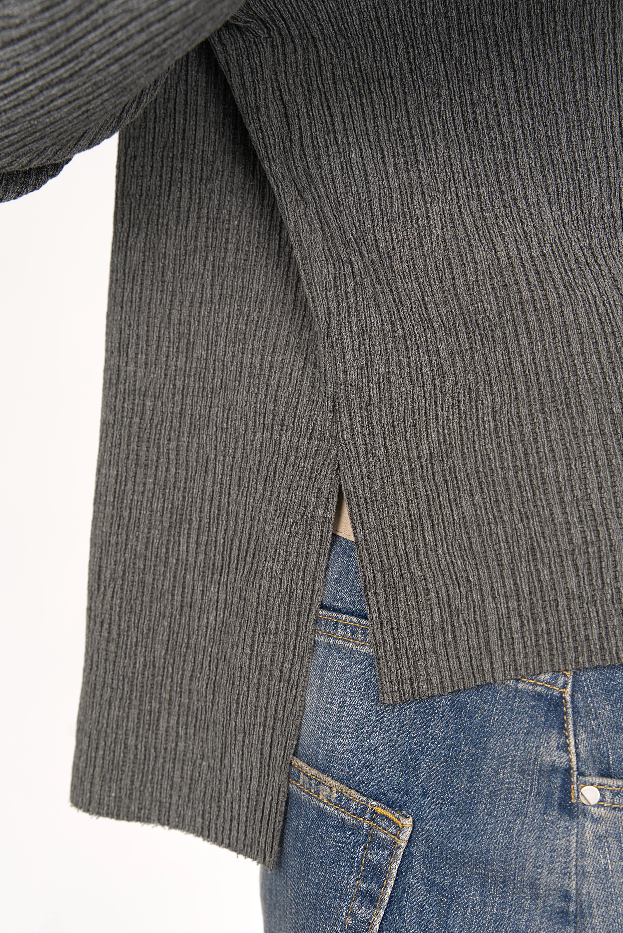 Close-up of grey plissierted crepe jersey NORELI Longsleeve with side slit and extended back hem worn with blue jeans