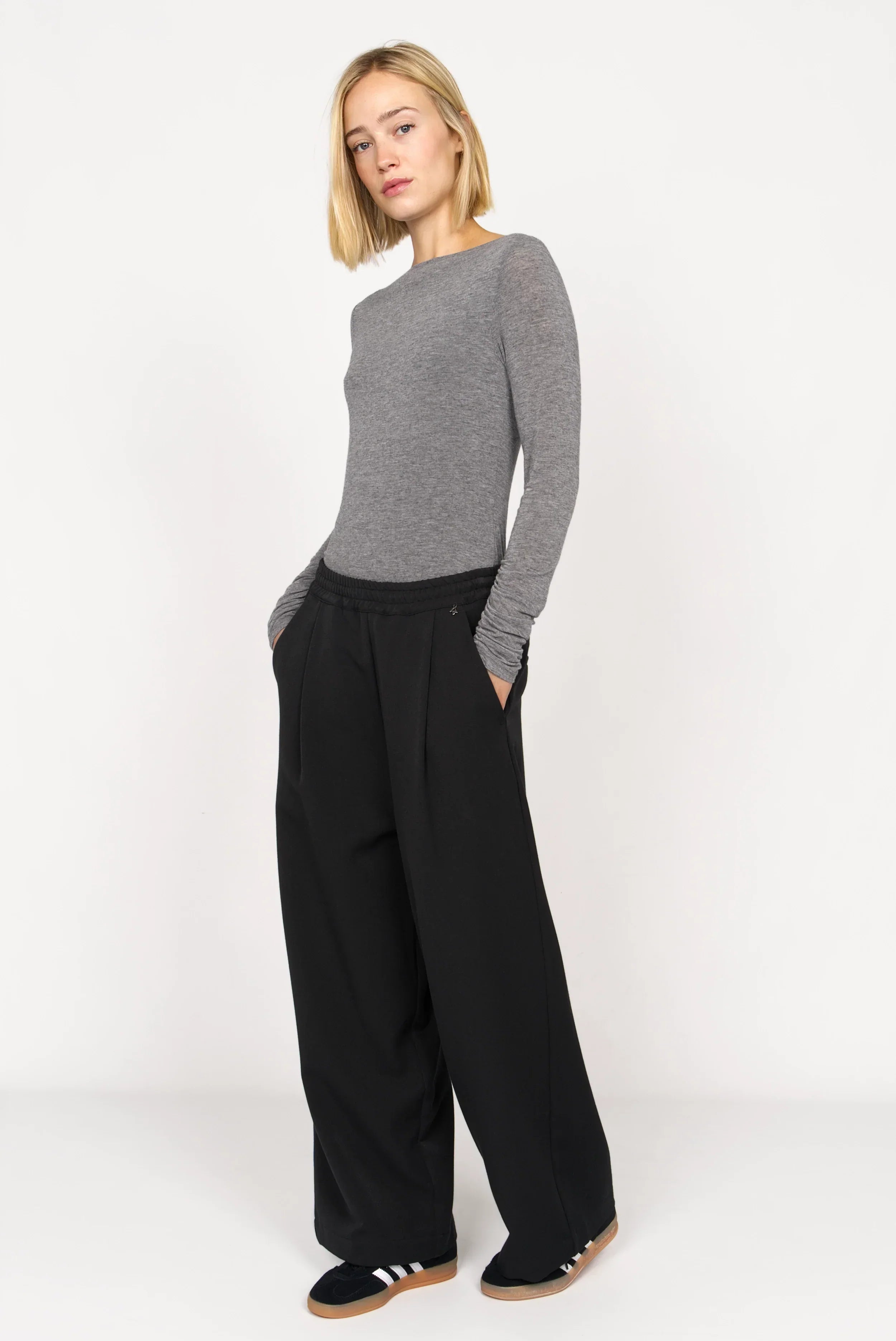Schwarze ONA Wide-Leg Hose mit elastischem Bund und seitlichen Taschen, kombiniert mit grauem Langarmshirt