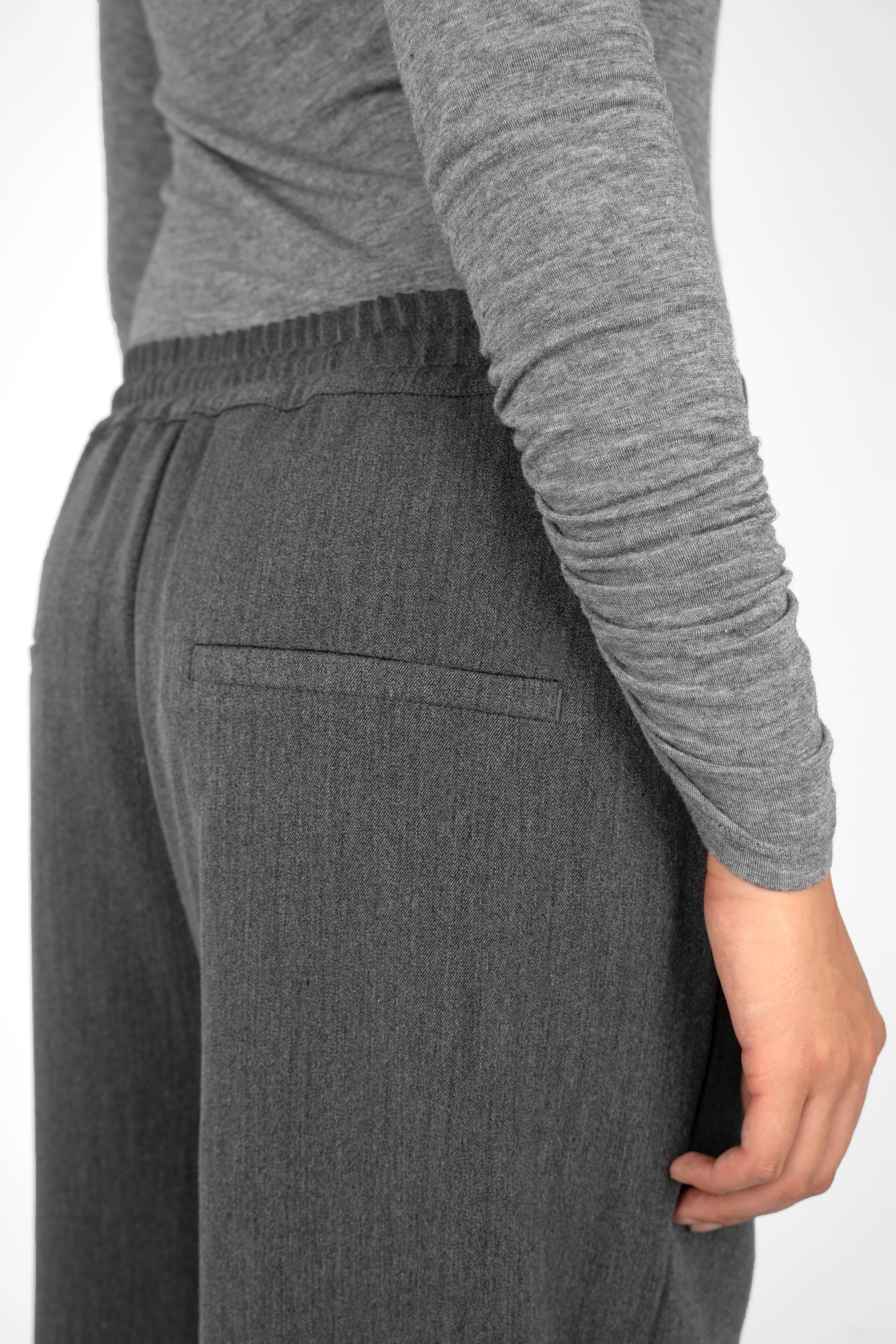 Back view of person wearing ONAH Wide-Leg Hose in dark grey with elastic waistband and side pockets