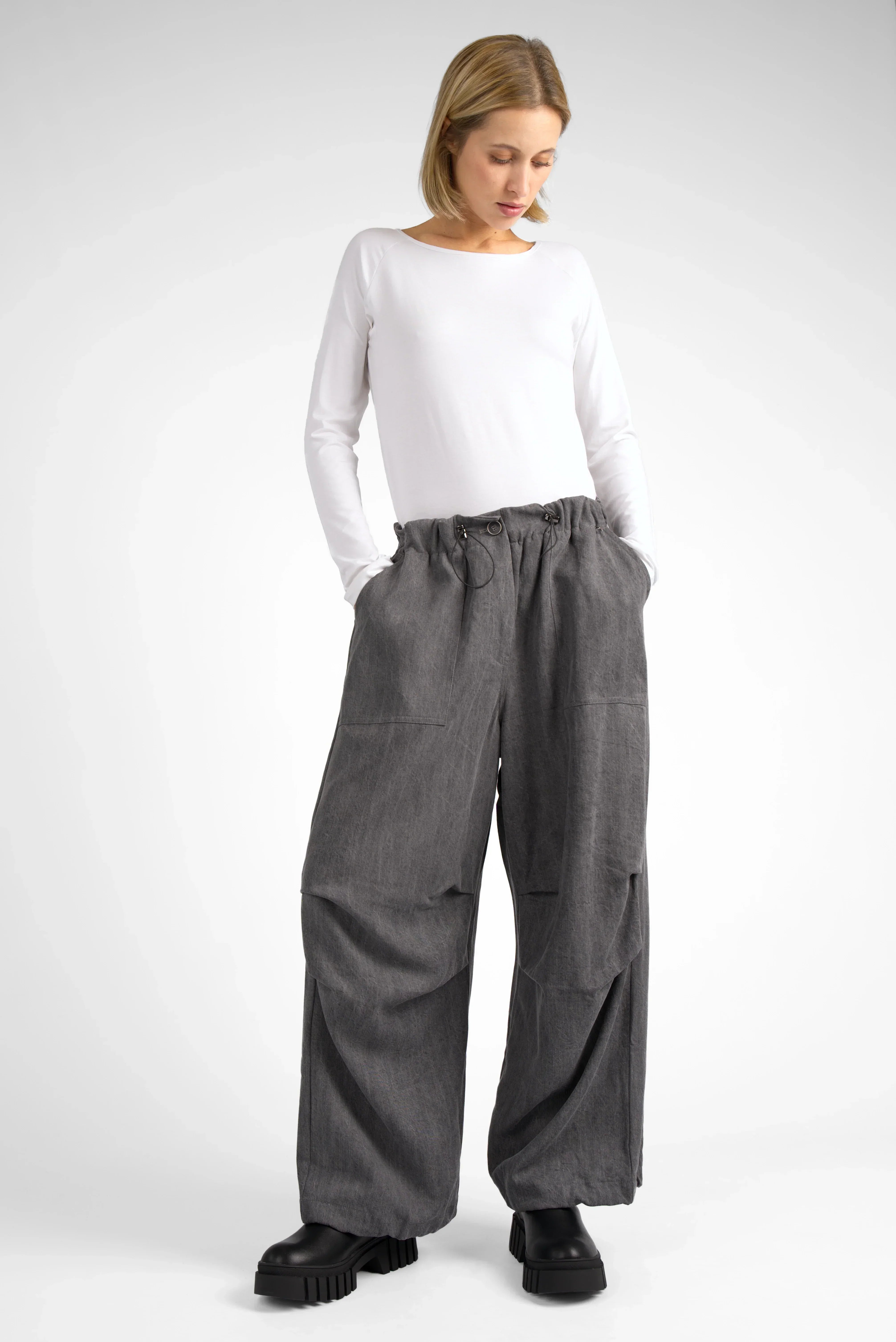 Frau trägt lässige graue Baggy Parachute-Hose mit elastischem Bund und großen Taschen