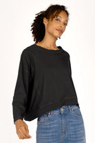 OSASU Cropped Longsleeve in schwarzer Kastenform mit weitem Rundhalsausschnitt und geschnittenen Kanten, locker fallend aus weicher Baumwolle.