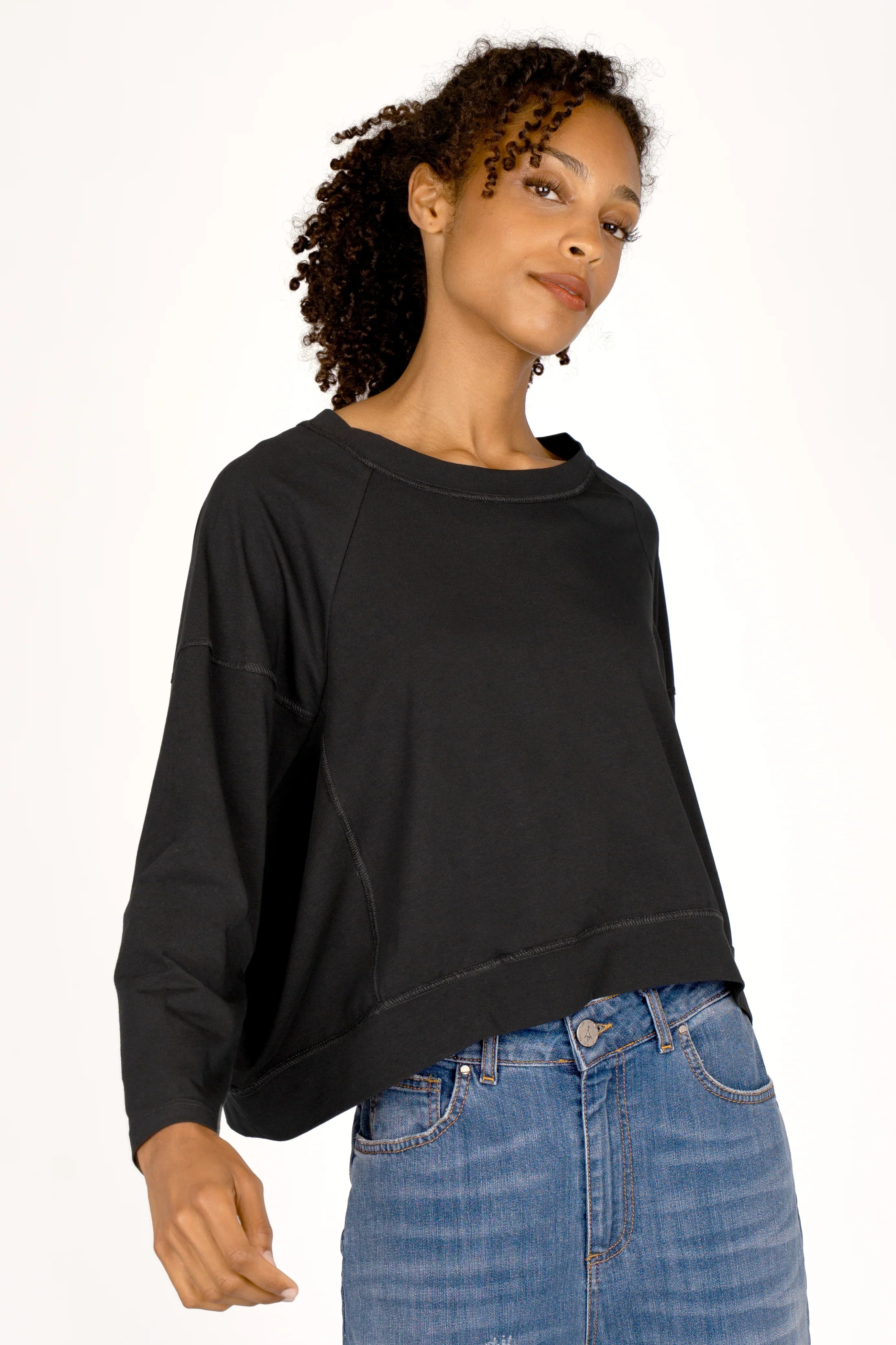 OSASU Cropped Longsleeve in schwarzer Kastenform mit weitem Rundhalsausschnitt und geschnittenen Kanten, locker fallend aus weicher Baumwolle.