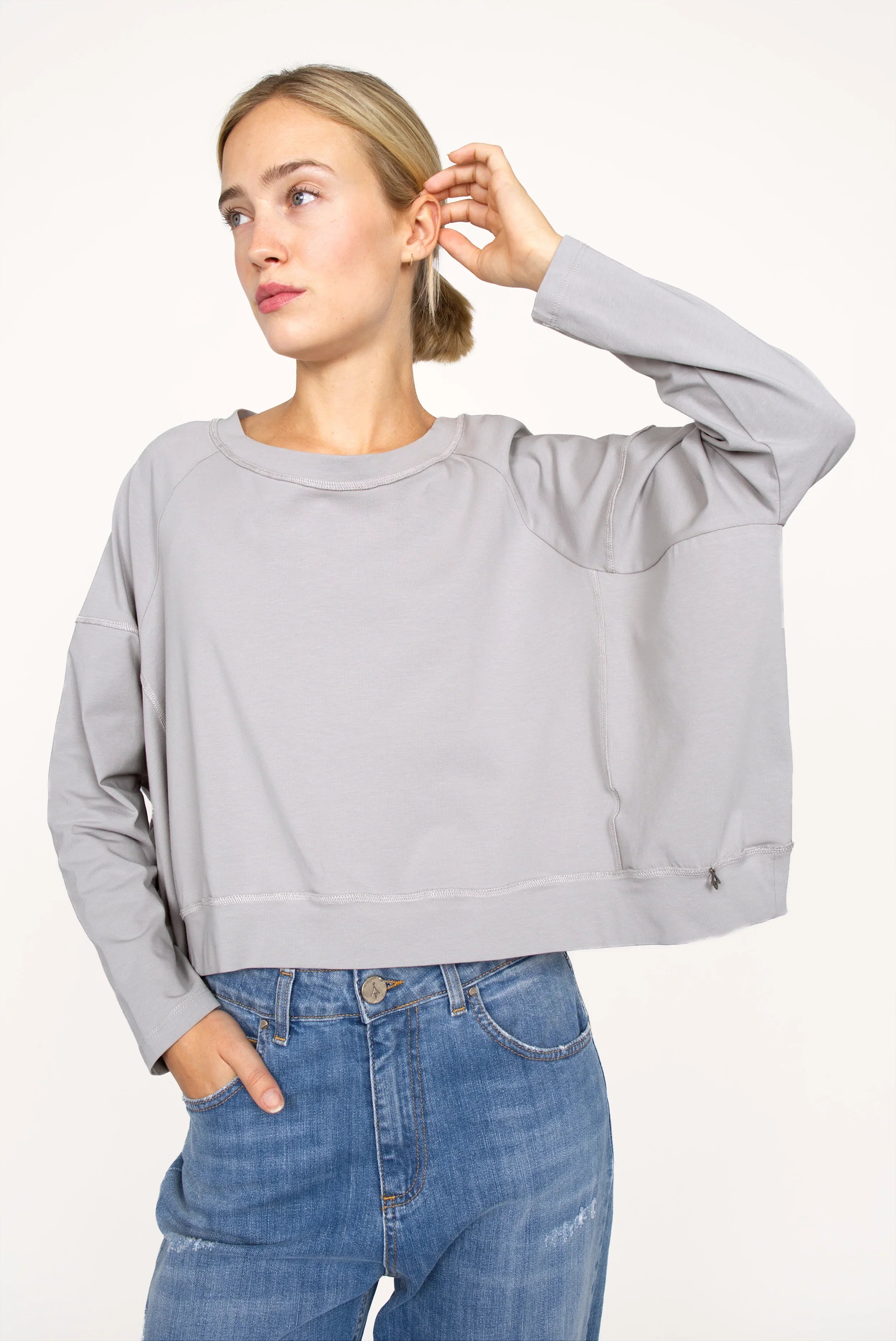 OSASU Cropped Longsleeve in light grey with wide round neckline and relaxed boxy fit on model wearing blue jeans