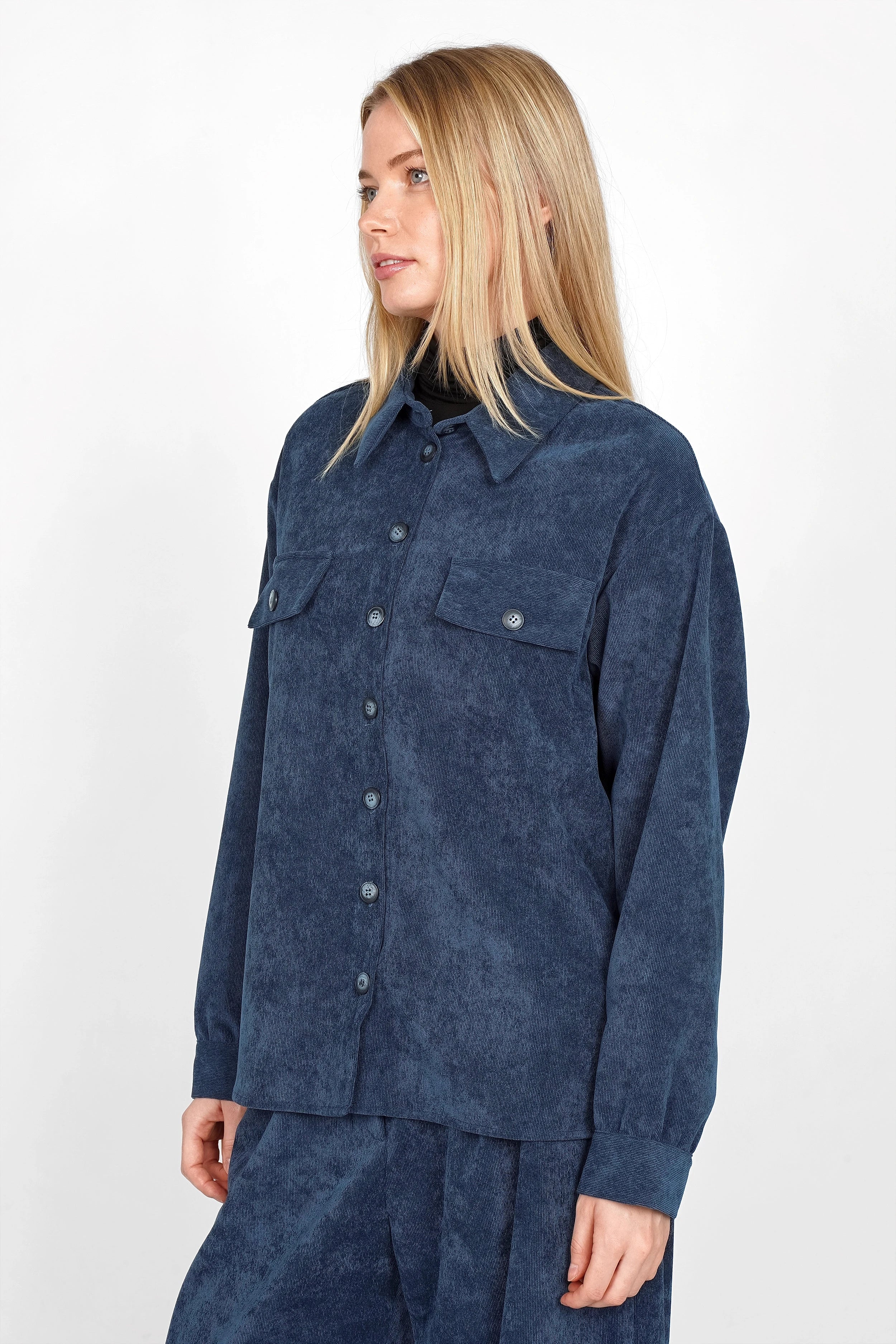 Woman wearing navy blue POULA Cord Overshirt with buttoned front and chest pockets in relaxed fit