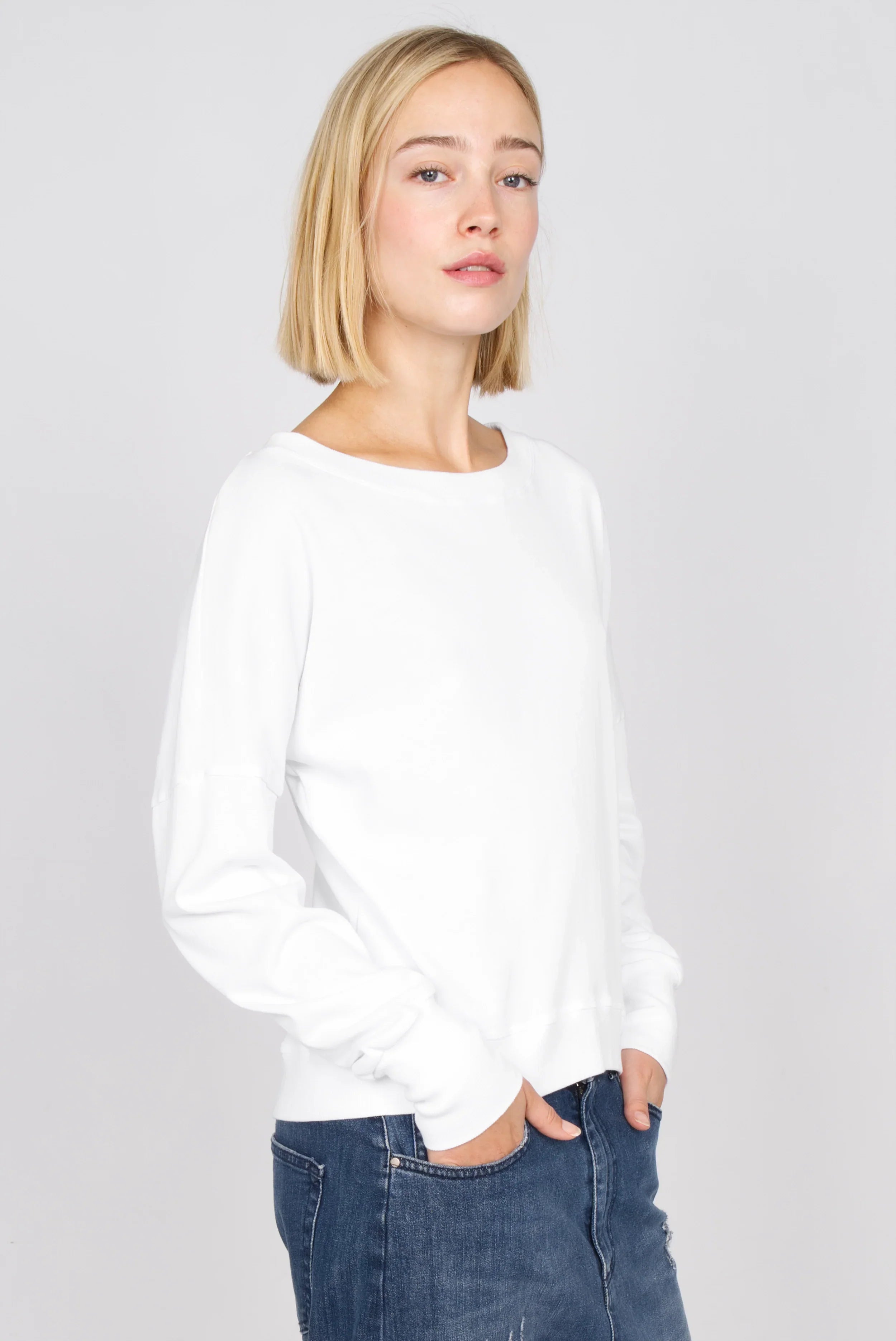 White RIISA Longsleeve with boat neckline, dropped shoulders, and ribbed cuffs, worn by female model