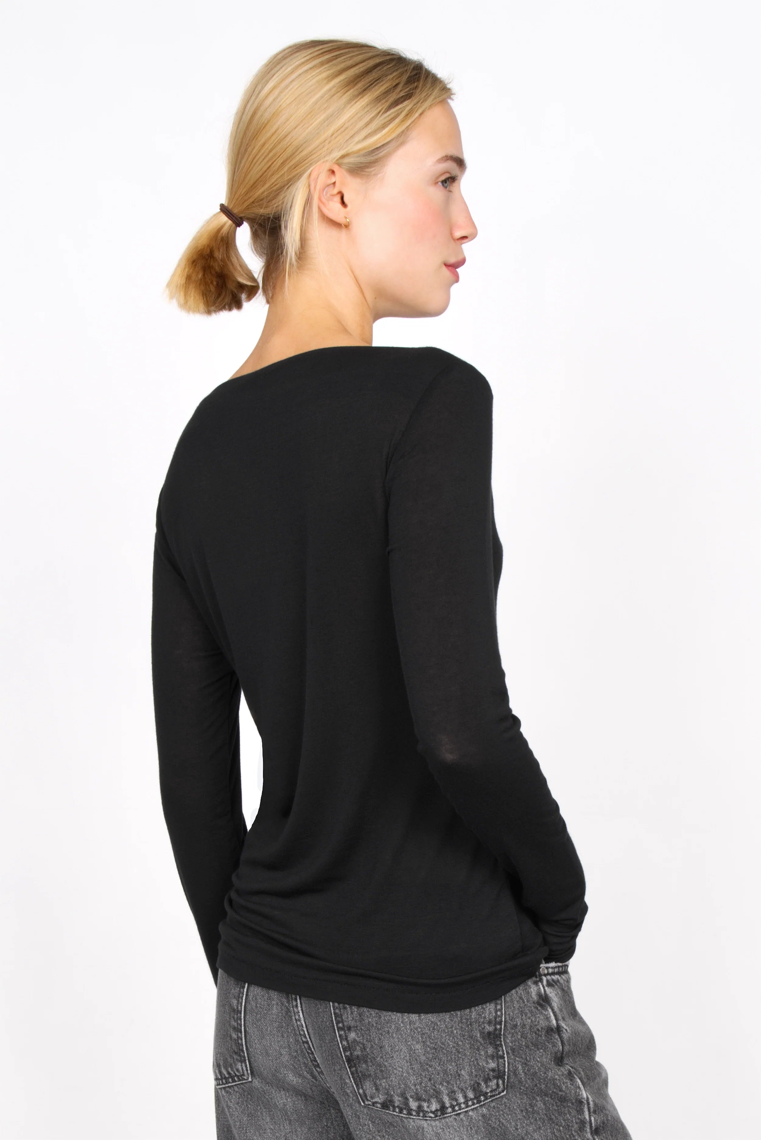 Schwarzes Longsleeve aus Kaschmirmix mit U-Boot Ausschnitt und langer enger Passform, zarter Semitransparenz, anliegend am Körper.