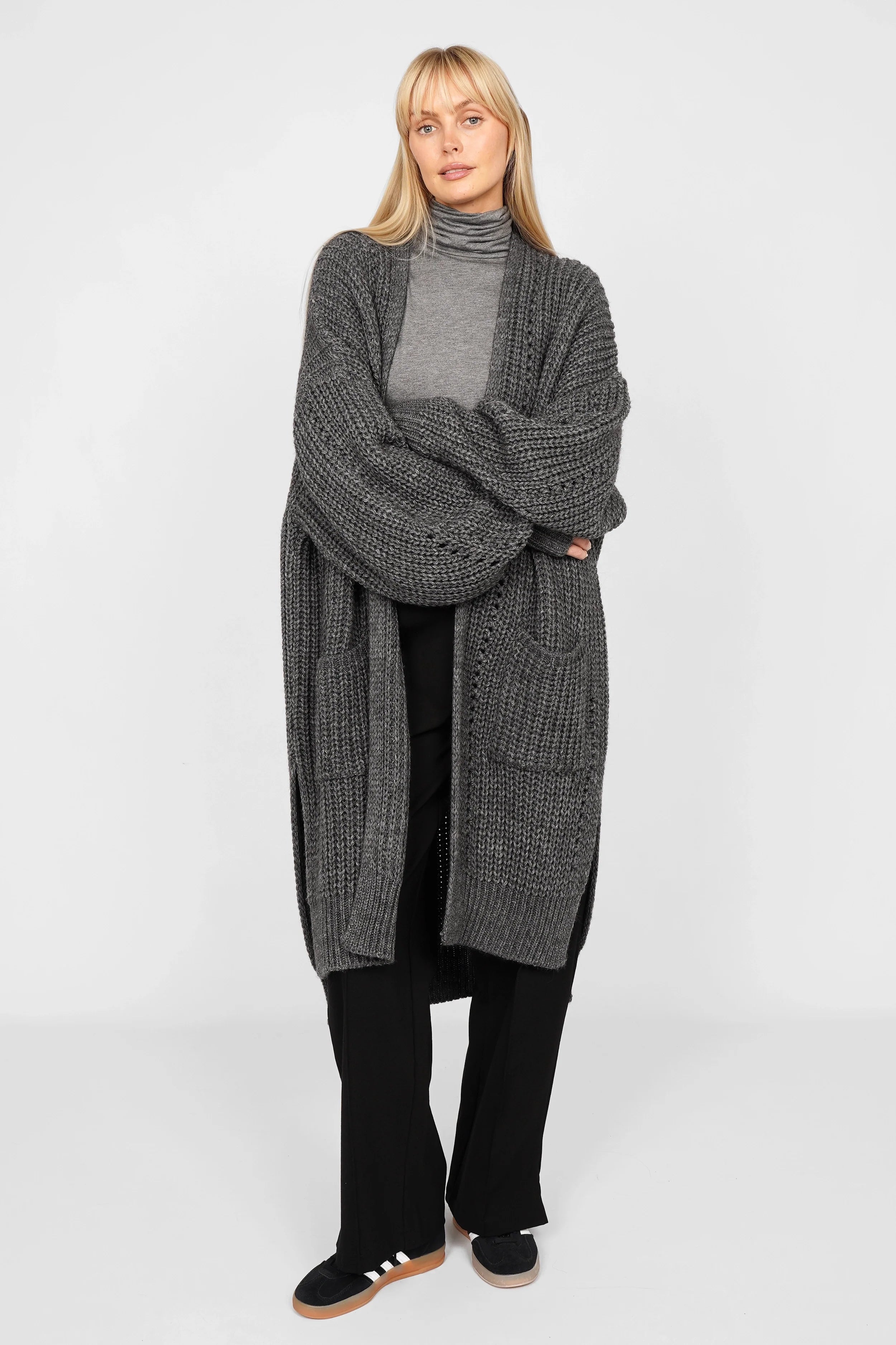 Dunkelgrauer Longcardigan aus Ajour-Strick mit Alpakawolle, oversize, weite Ärmel, aufgesetzte Taschen, seitliche Schlitze, hinten länger geschnitten.