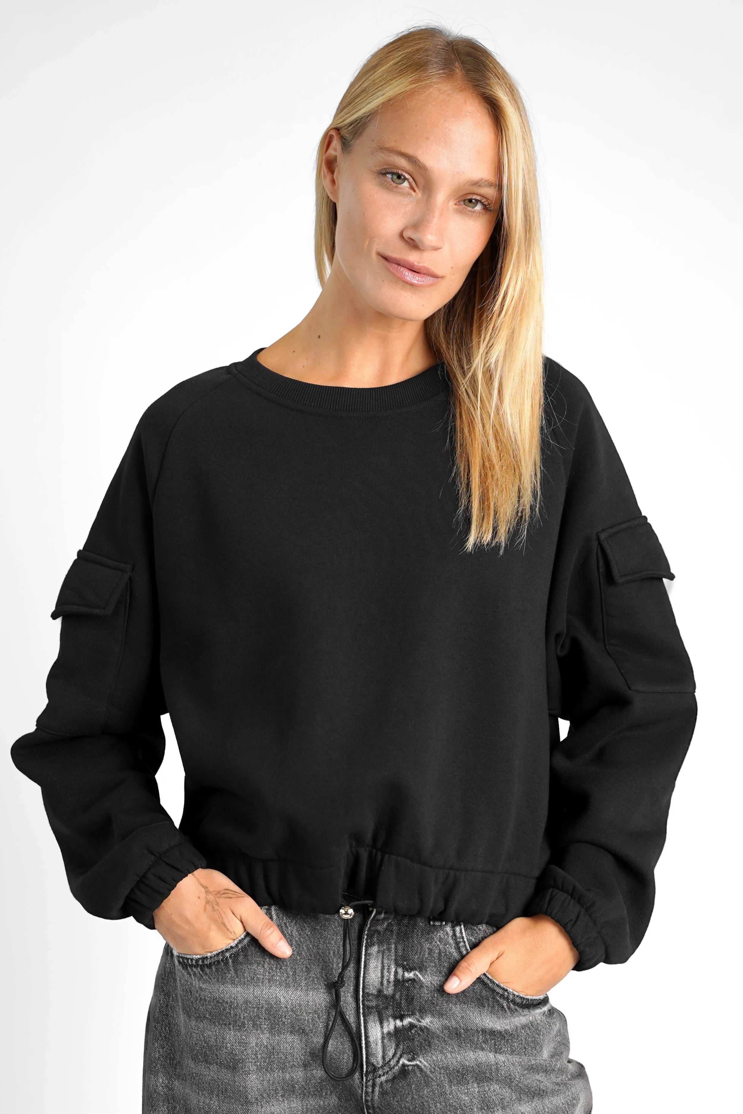 Black SEATA cropped sweater with round neckline, oversized fit, drawstring waist, elastic cuffs, and patch pockets on sleeves.
