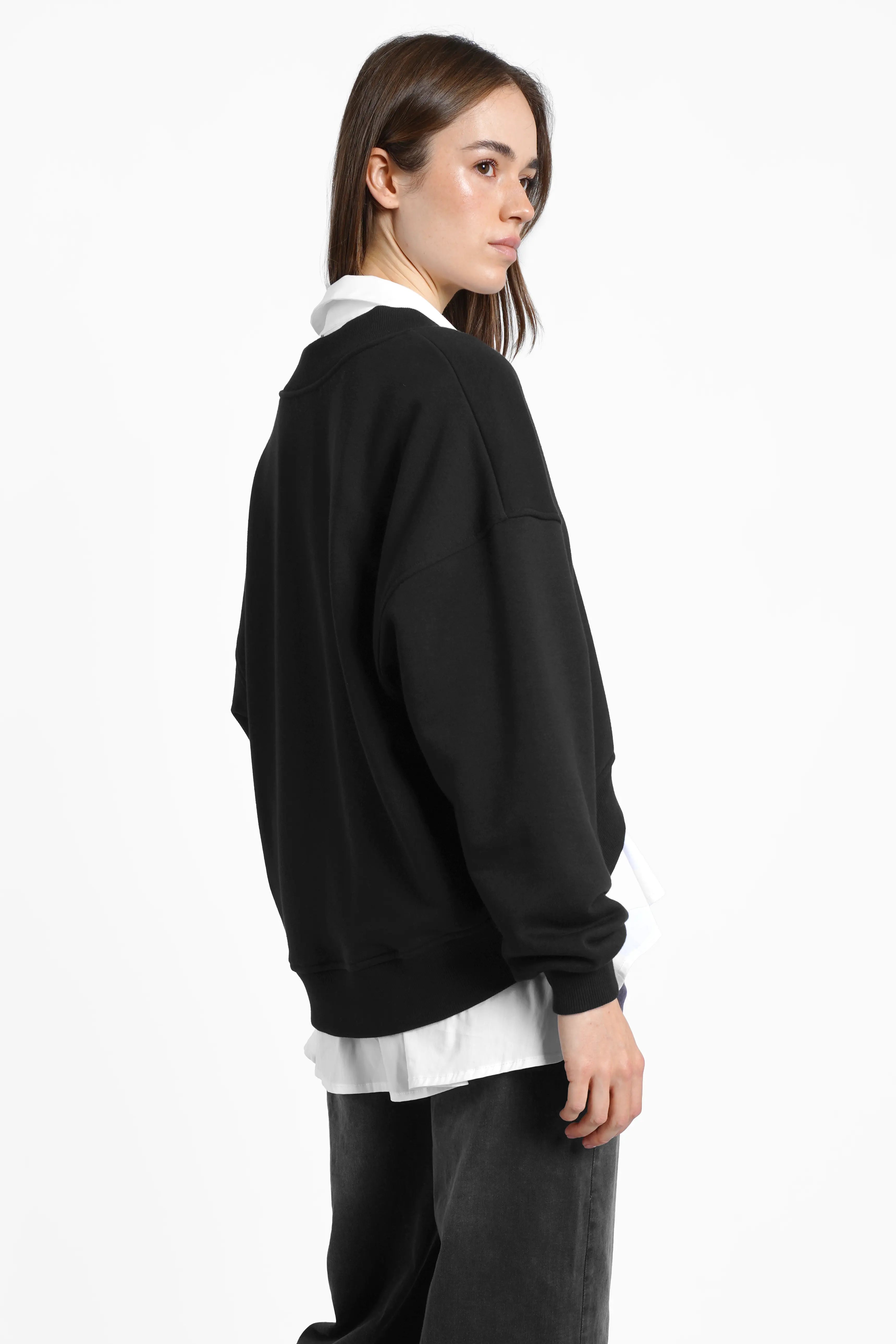 SEREA Sweater black relaxed fit with deep V-neck and ribbed cuffs shown from the back on model