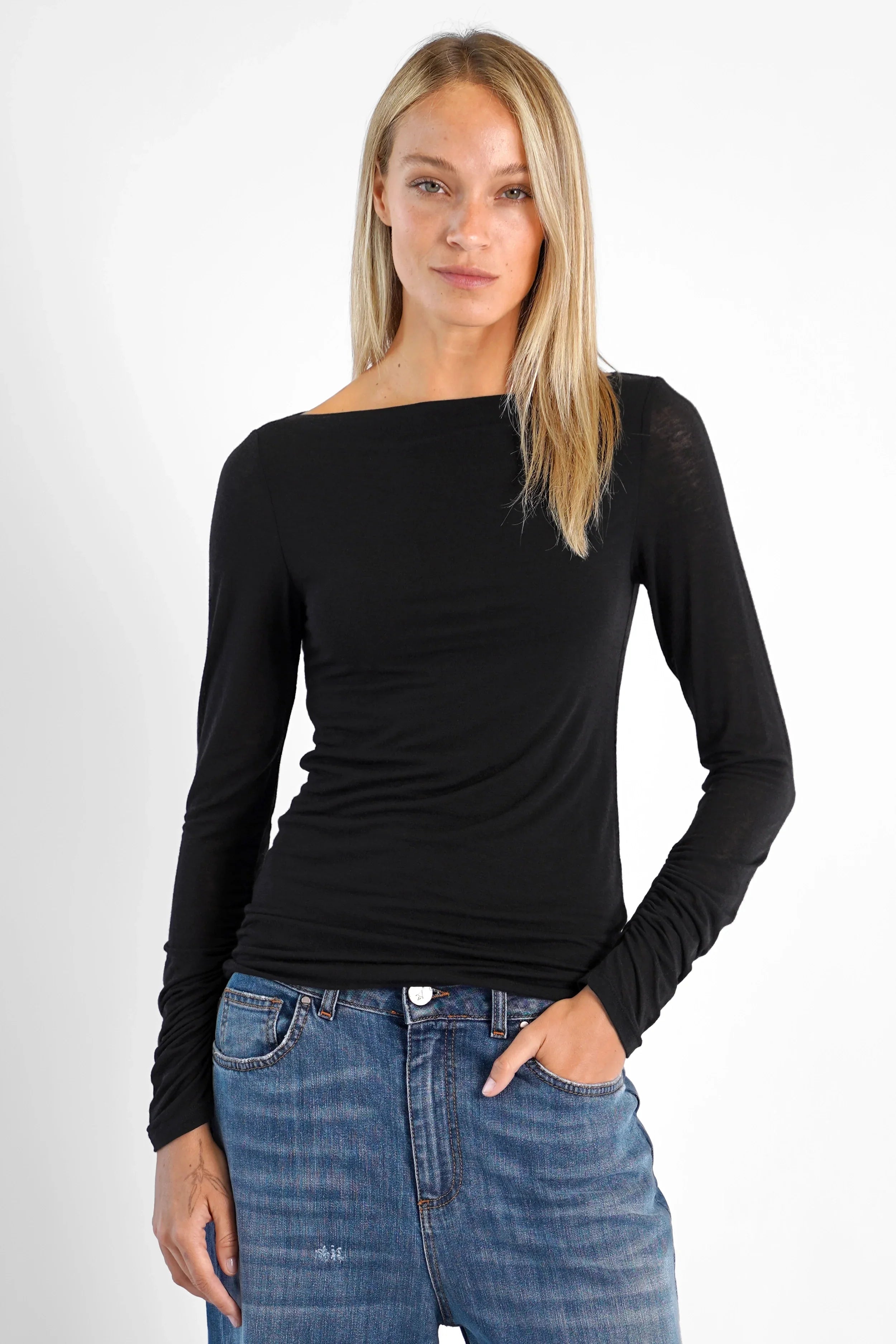 Feminines schwarzes SUJIN Longsleeve aus Kaschmirmix mit U-Boot-Ausschnitt und gerafften Ärmeln, slim fit, kombiniert mit Jeans.