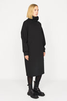 Black SYNNI Känguru-Tasche dress with loose turtleneck, long sleeves, and front kangaroo pocket.