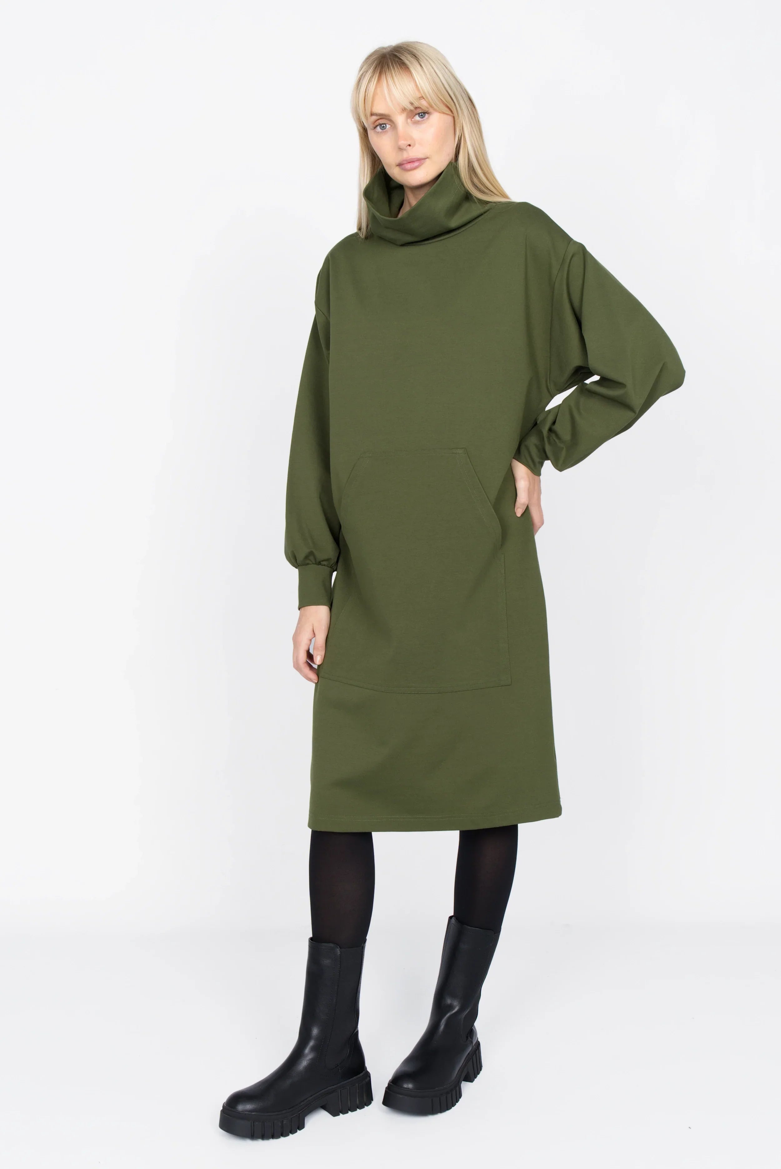 SYNNI Kleid aus grünem Viskose-Jersey mit Stehkragen und Kängurutasche, lässiger Schnitt, langärmlig, modelliert mit schwarzen Stiefeln