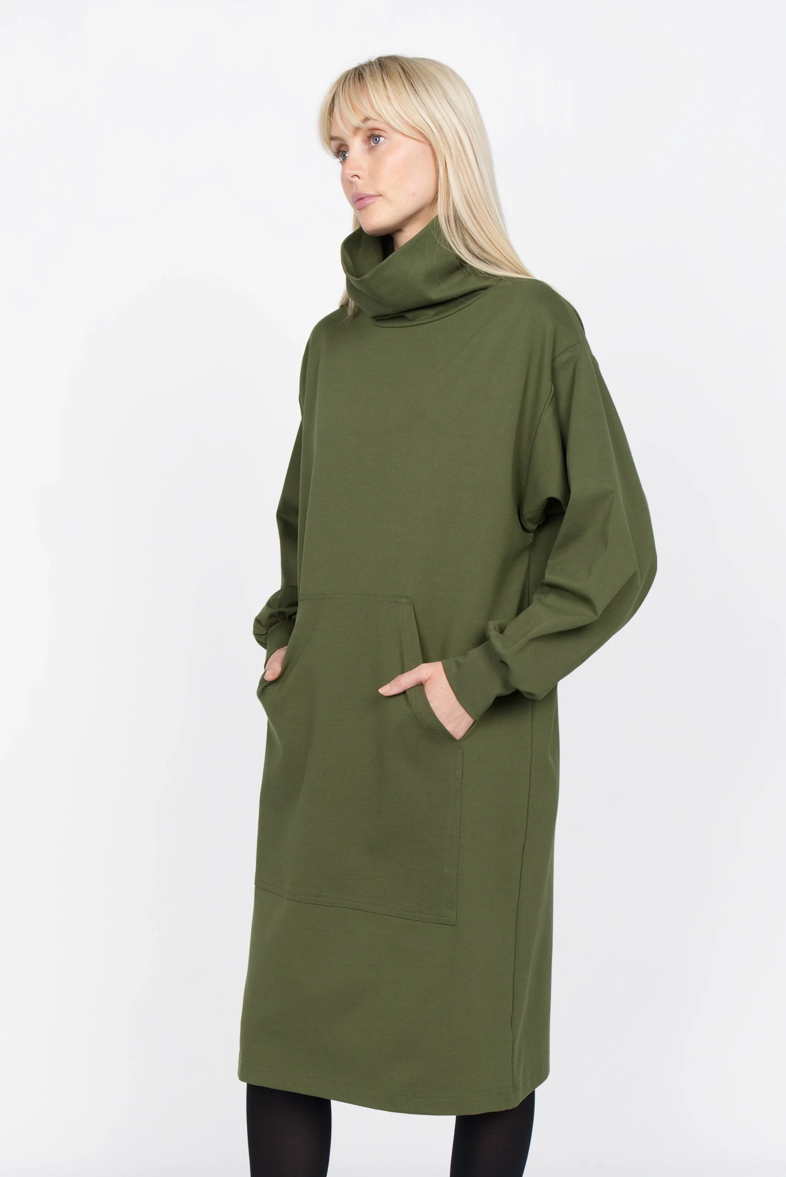 Frau trägt olivgrünes SYNNI Kleid aus Viskose-Jersey mit Stehkragen und Kängurutasche