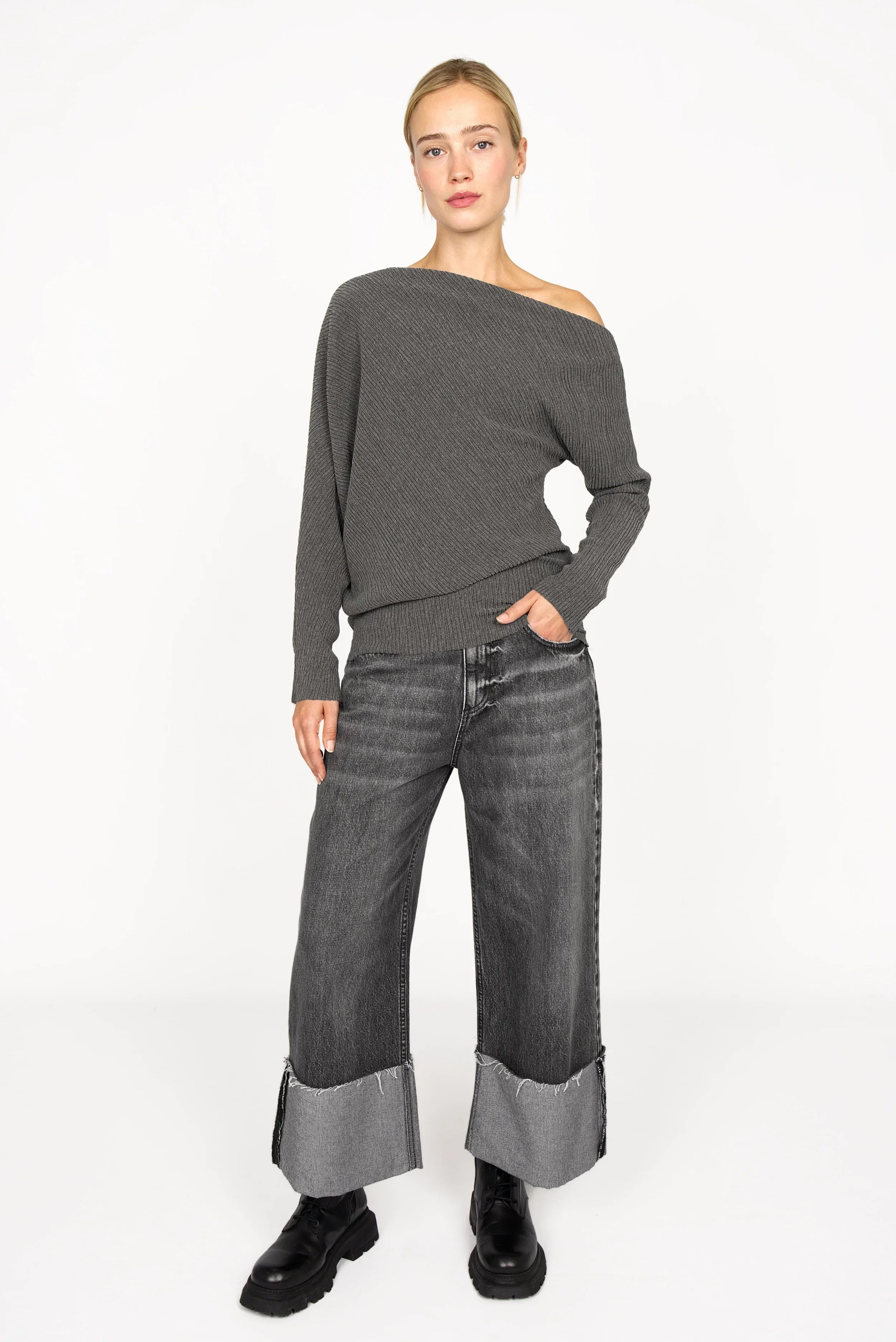 Frau trägt asymmetrisches One-Shoulder Top aus plissiertem Kreppjersey in Grau