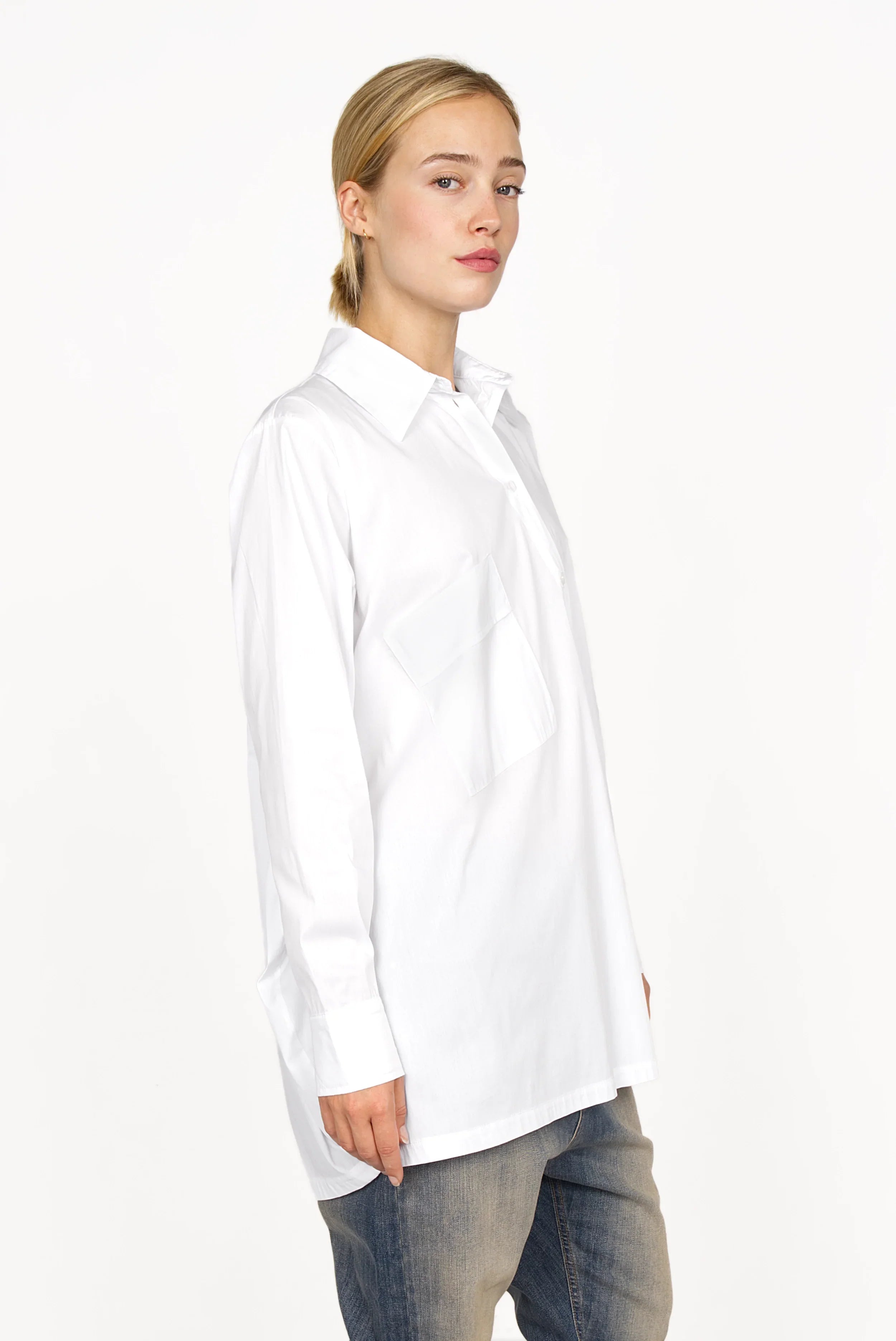 Woman wearing white oversized Hemdbluse with asymmetrical button placket and dropped shoulders