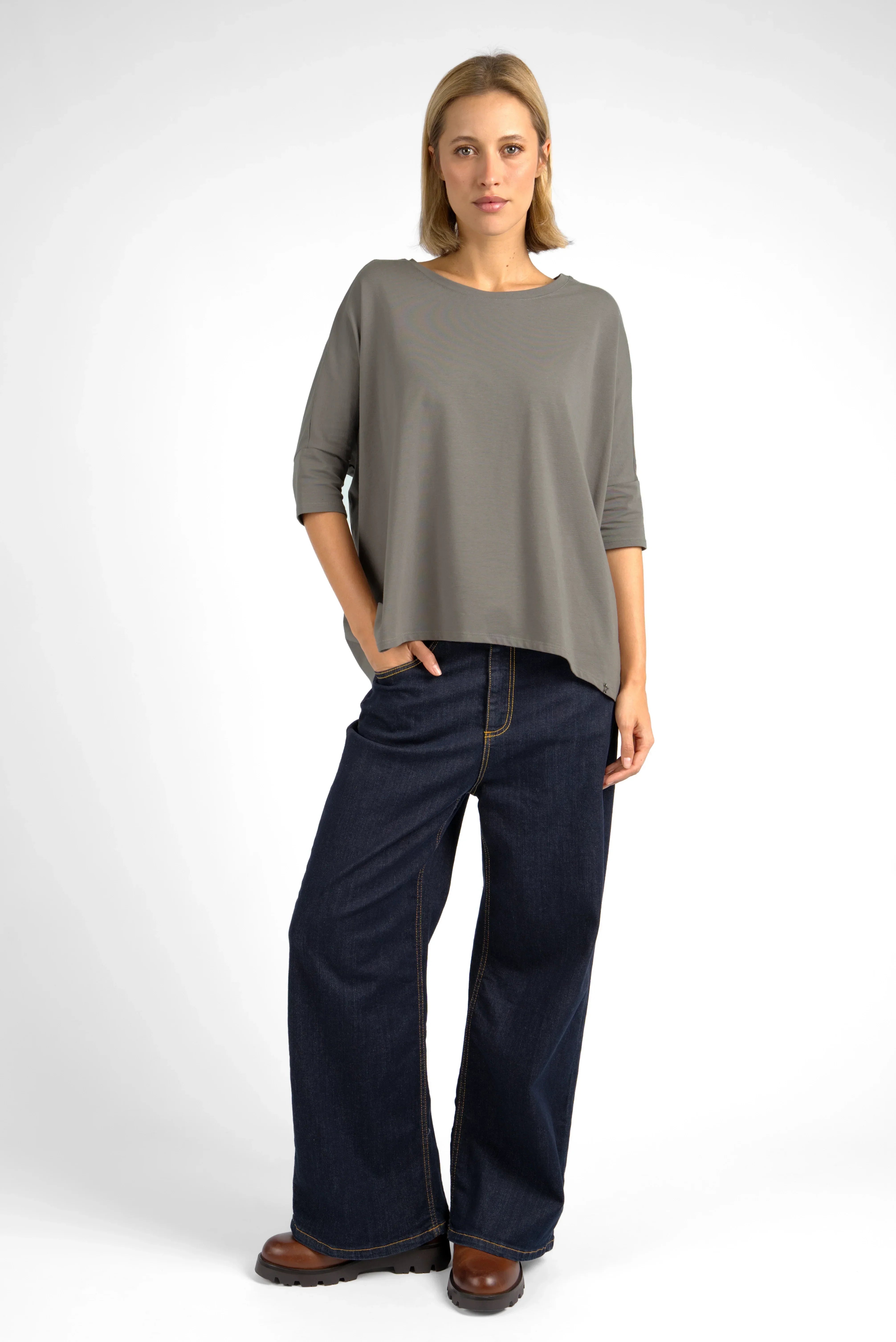 Woman wearing grey TAMI.K Blusenshirt with relaxed fit and round neckline paired with wide-leg jeans