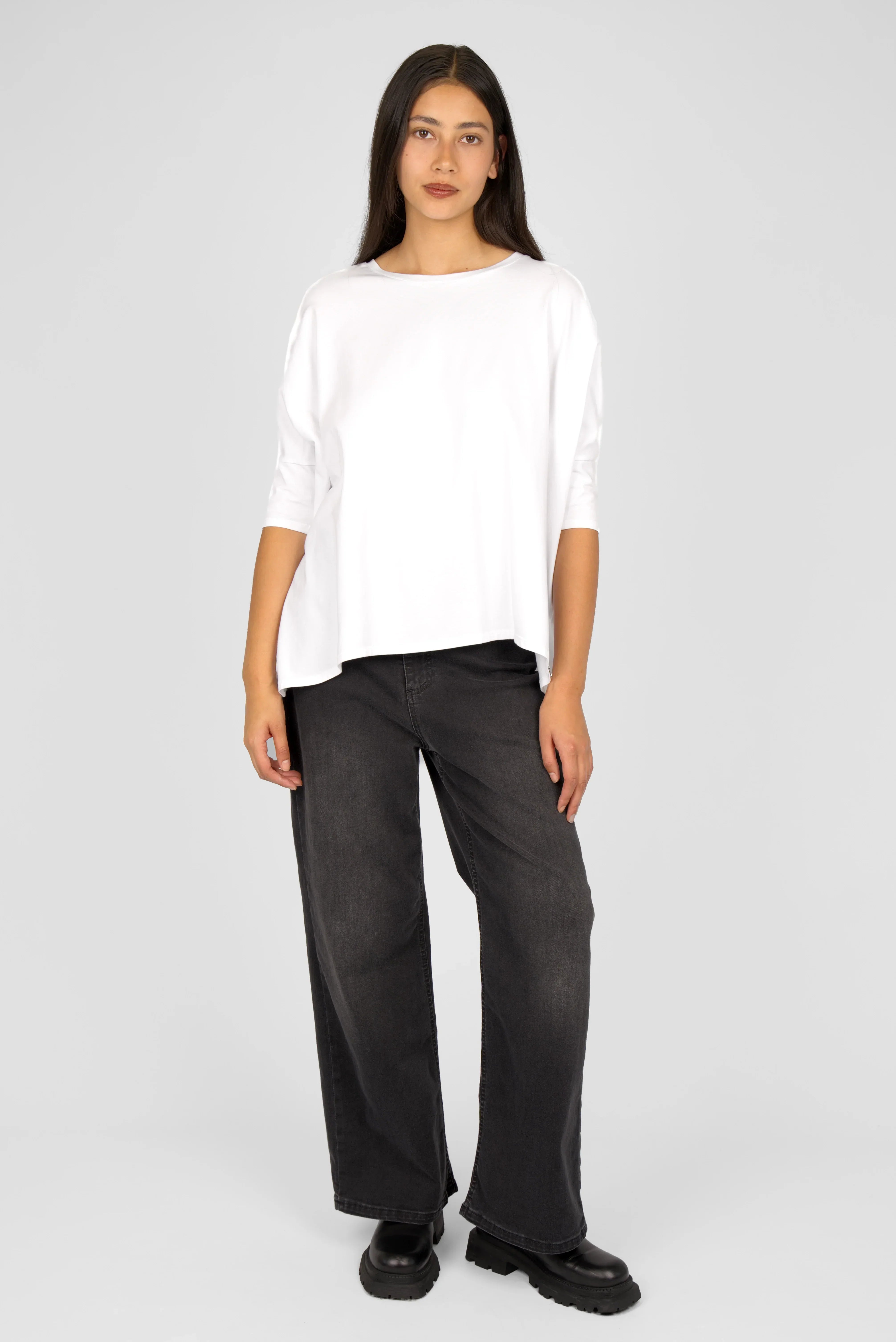 Frau trägt weißes TAMI.K Blusenshirt mit Rundhals und weiter Kastenform in Relaxed Schnitt