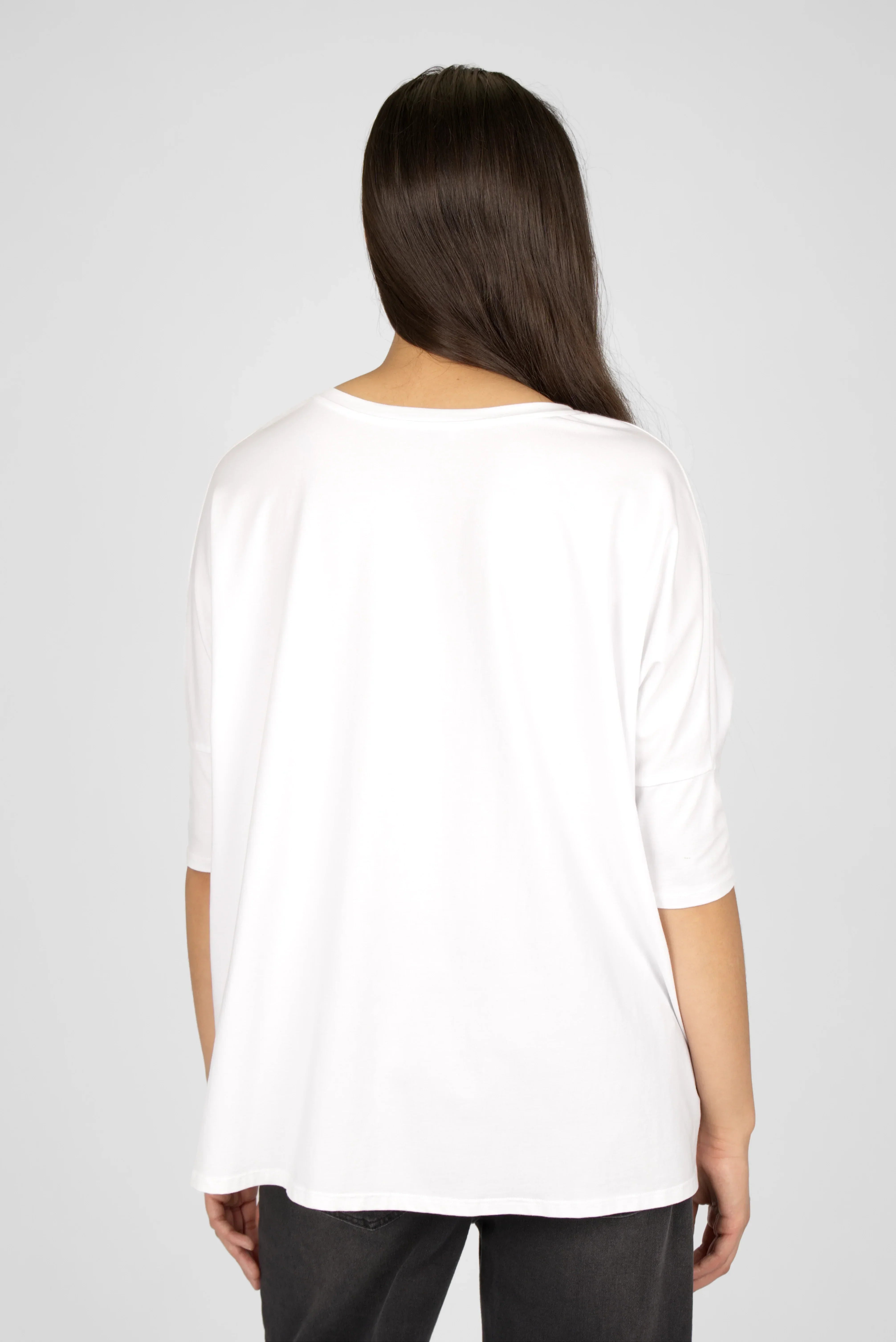 Frauen tragen weißes TAMI.K Blusenshirt in lockerer Kastenform mit Rundhalsausschnitt, Blick von hinten