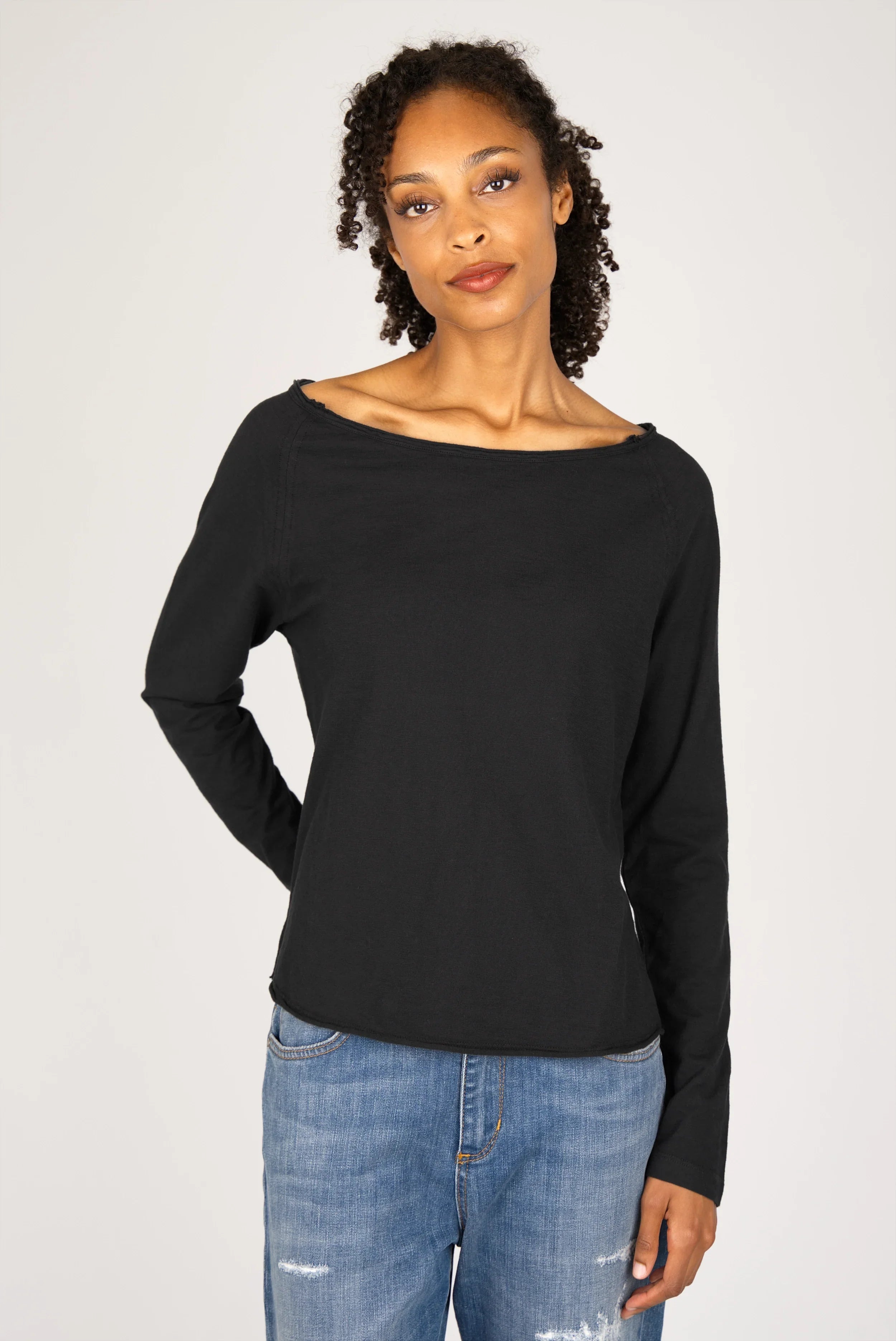 Woman wearing black TEHI Longsleeve with open neckline and long raglan sleeves
