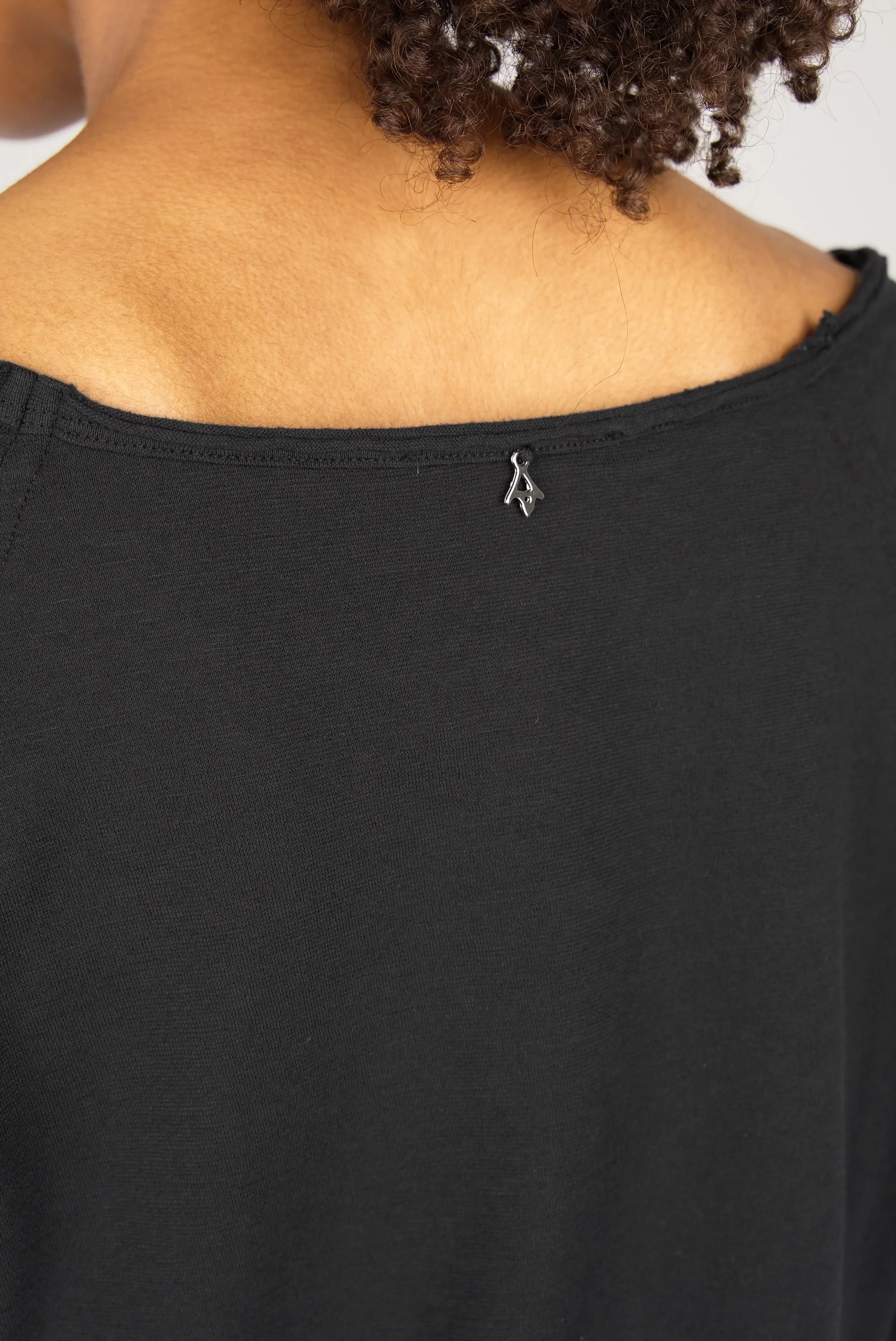 Close-up of black TEHI Longsleeve showing open neckline and soft cotton fabric detail
