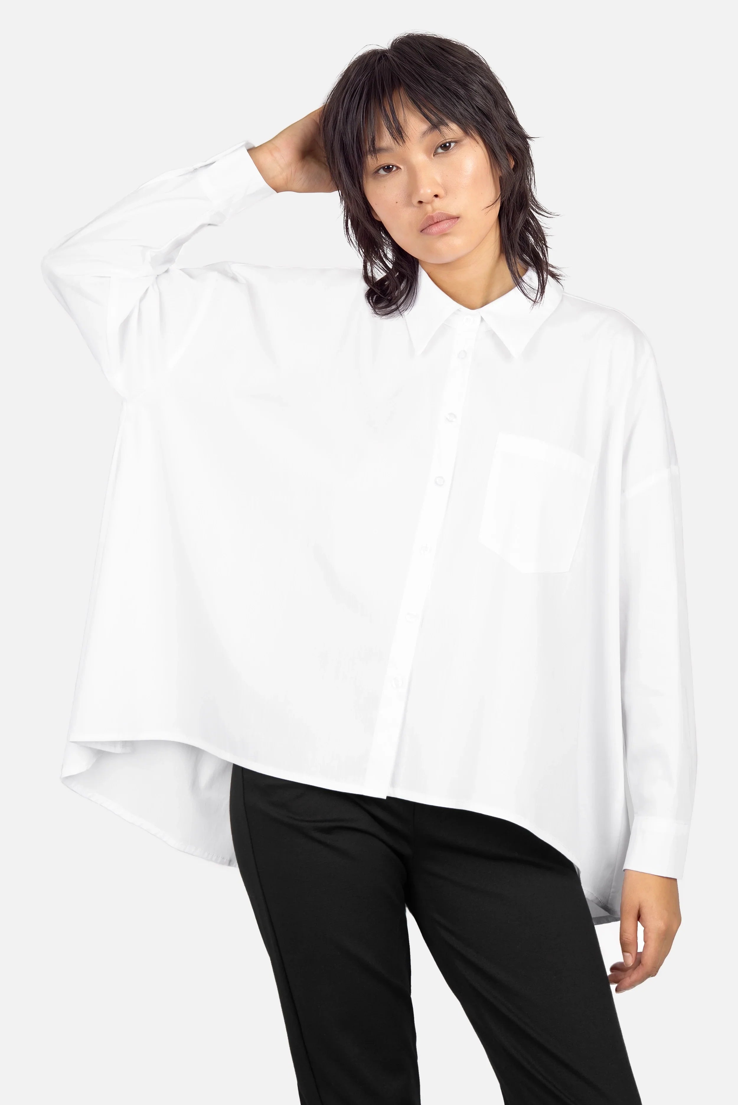 Damen trägt oversized Popeline Hemdbluse mit klassischem Kragen und A-Linien-Silhouette