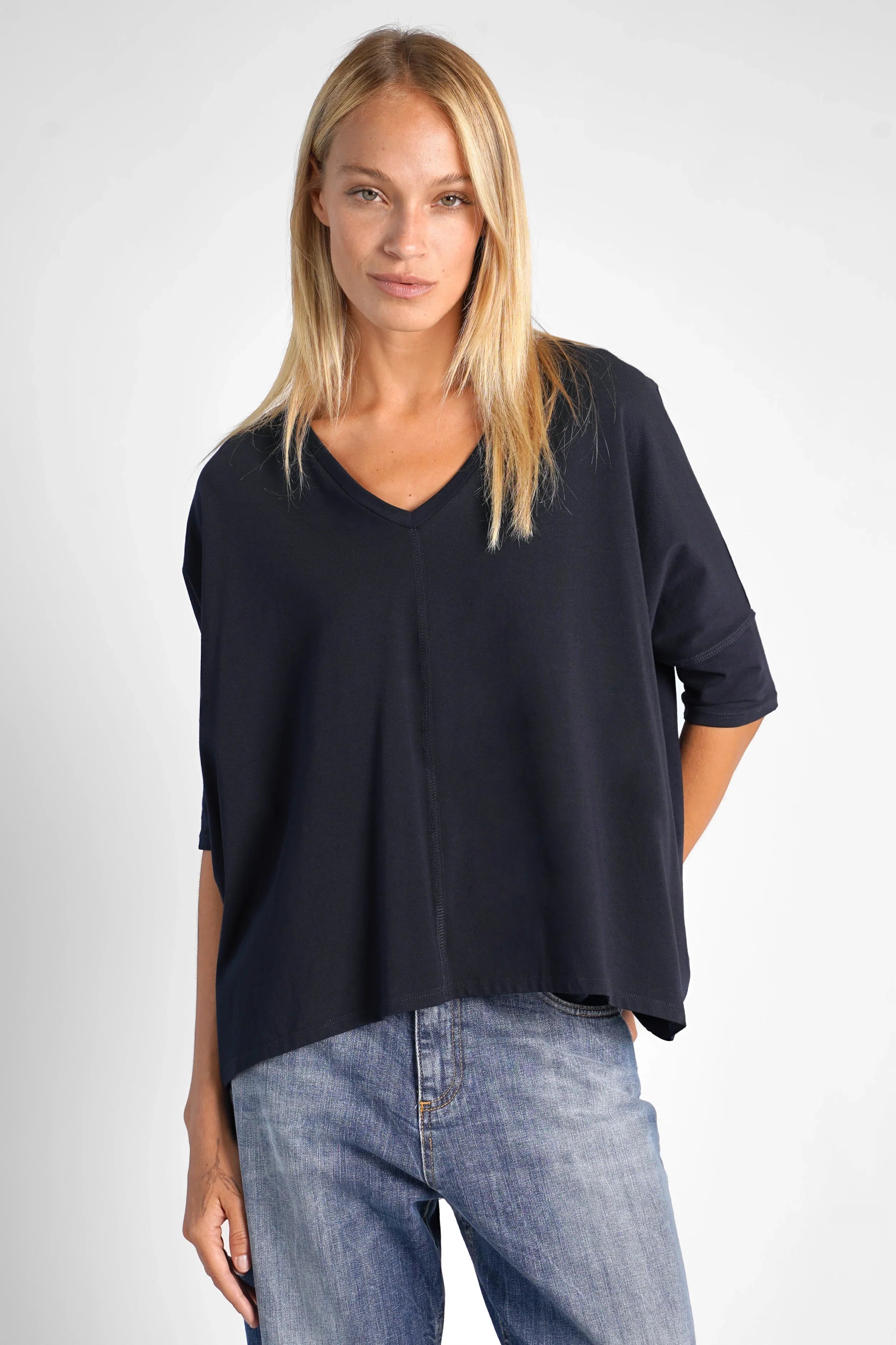 Damen trägt lockeres TIDA Blusenshirt mit V-Ausschnitt und Kastenform in Dunkelblau