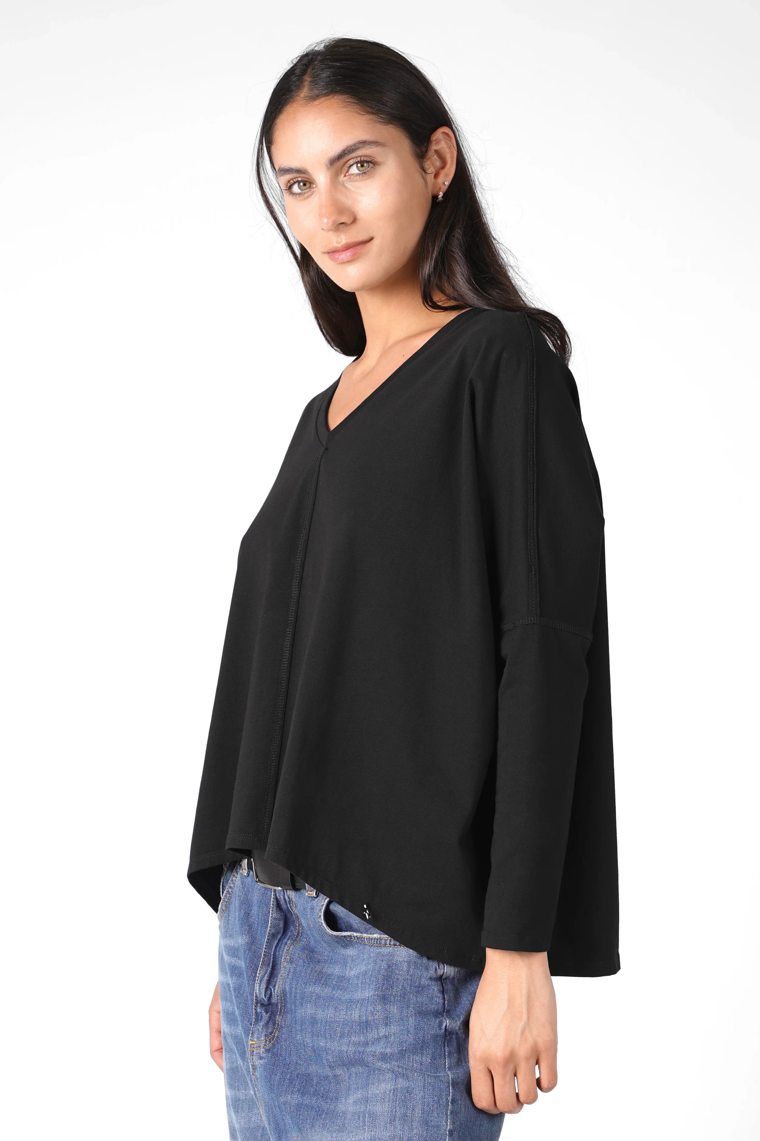 Woman wearing black TIDA Blusenshirt long-sleeve with V-neck and relaxed boxy fit paired with blue jeans