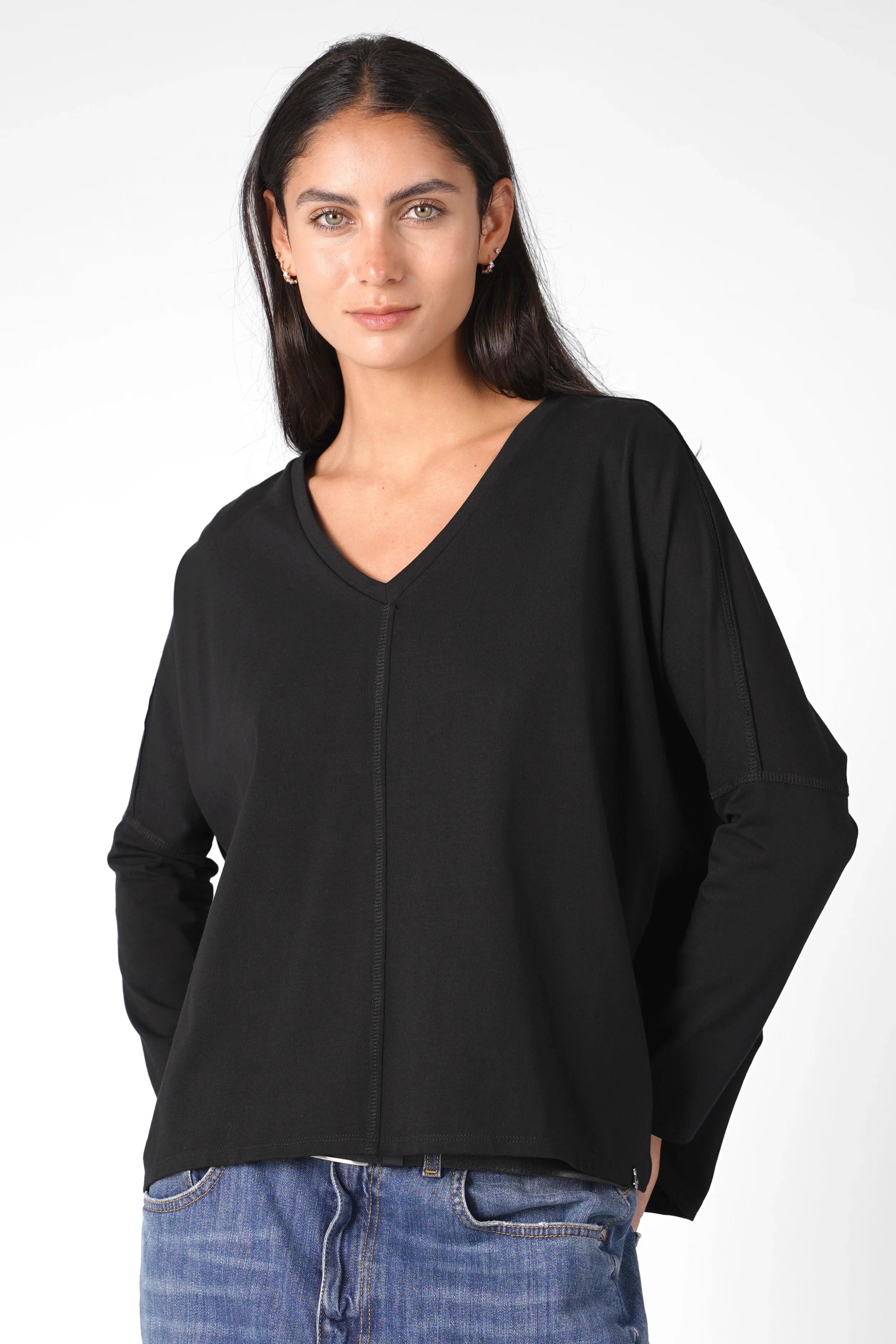 Woman wearing black TIDA Blusenshirt long sleeve V-neck relaxed fit blouse with rounded hem
