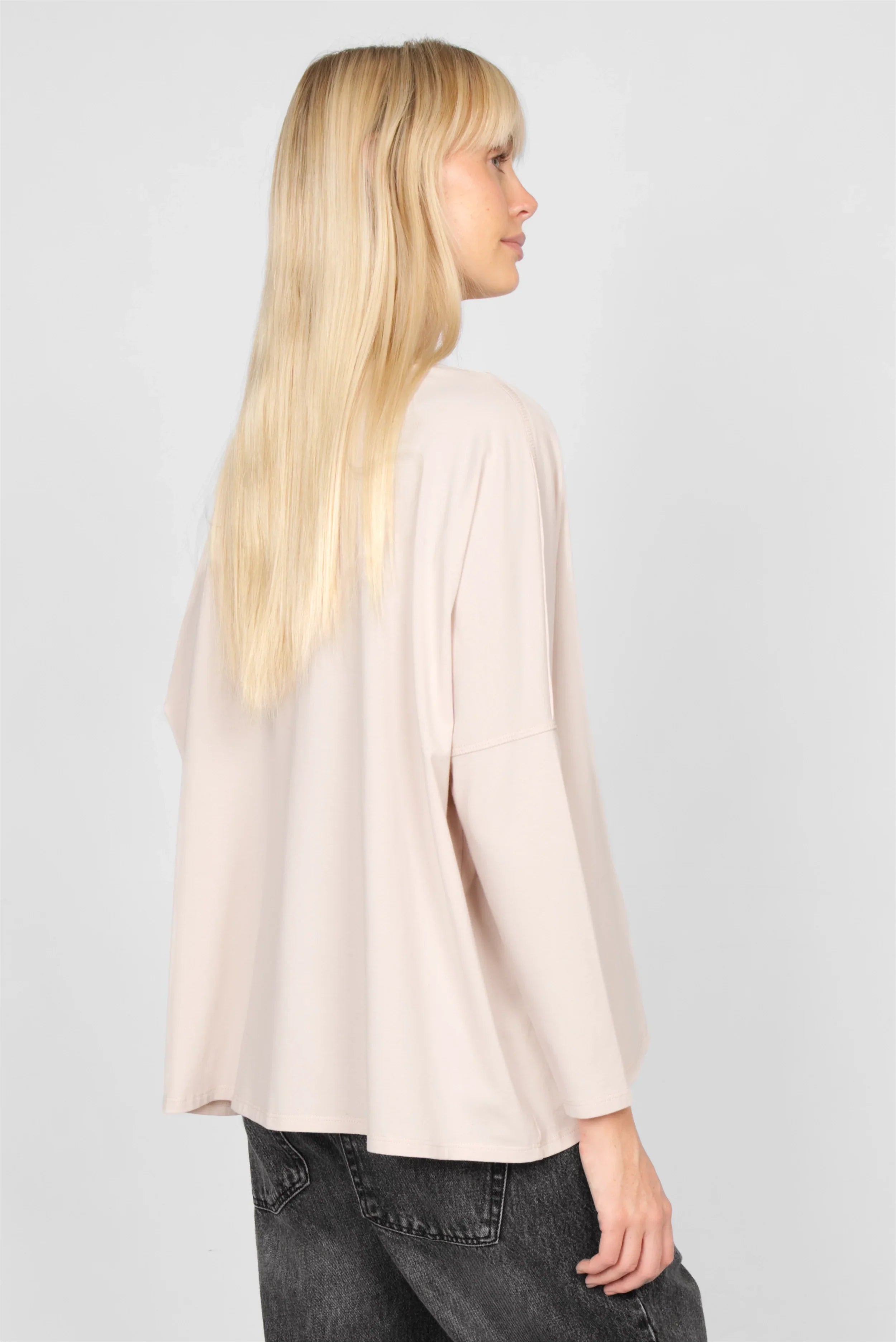 Frau trägt TIDA Blusenshirt Langarm in heller Farbe mit weitem, locker fallendem Schnitt und langer Rückenpartie