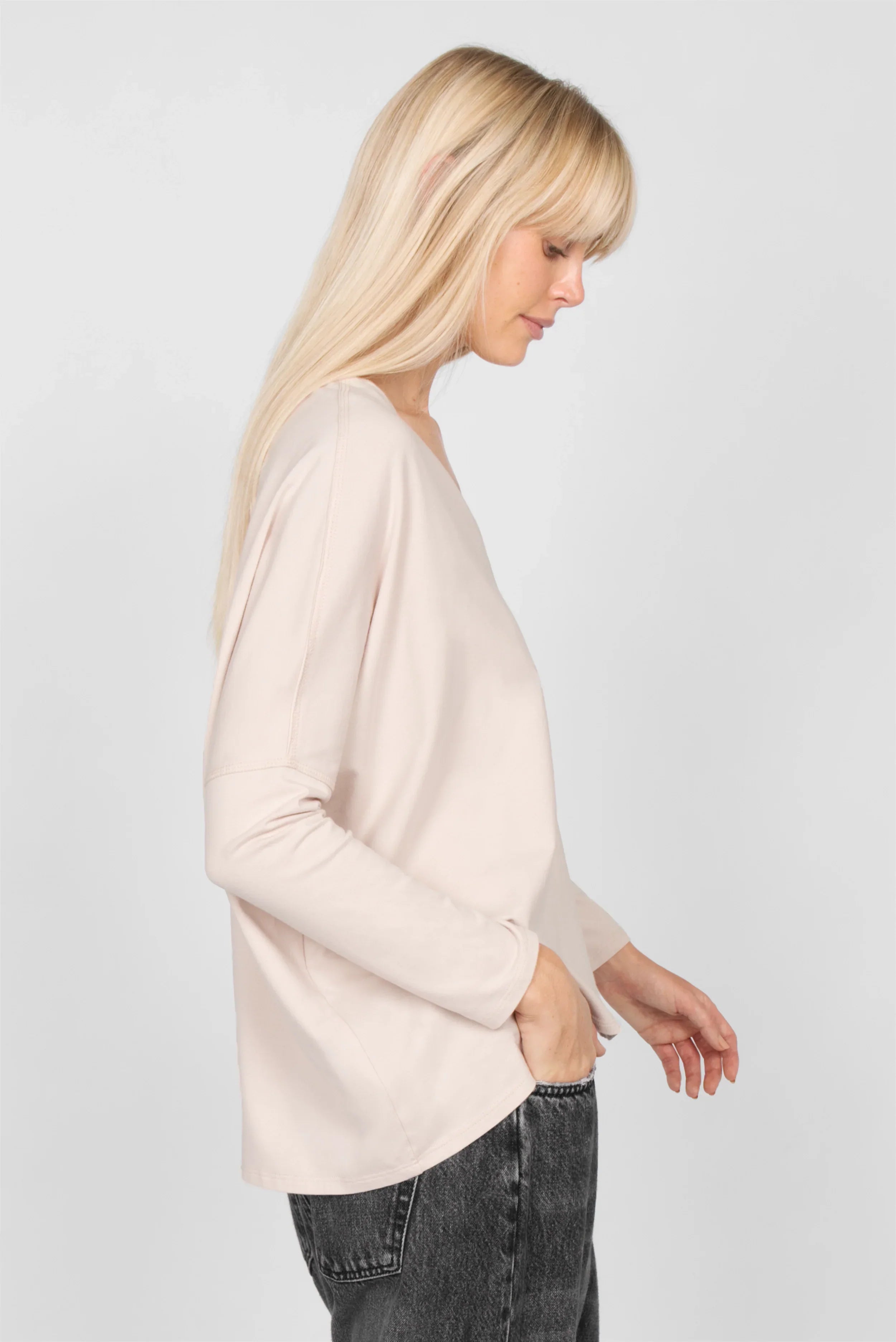 Seitenansicht eines Modells mit hellbeigem TIDA Blusenshirt Langarm mit V-Ausschnitt und lockerem Schnitt