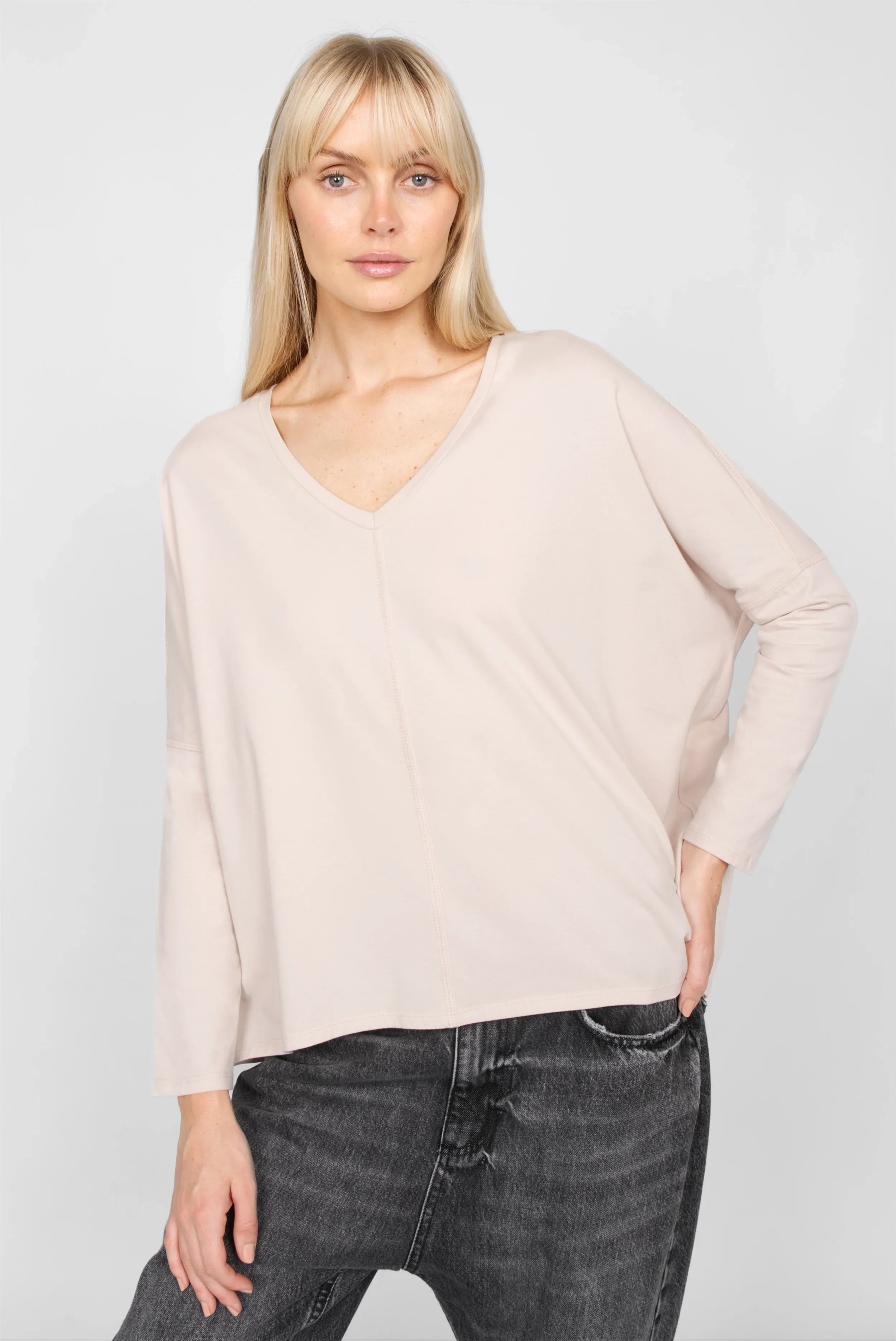 Damenmodel trägt TIDA Blusenshirt Langarm in lockerer Kastenform mit V-Ausschnitt und langen Ärmeln, hellrosa Farbe