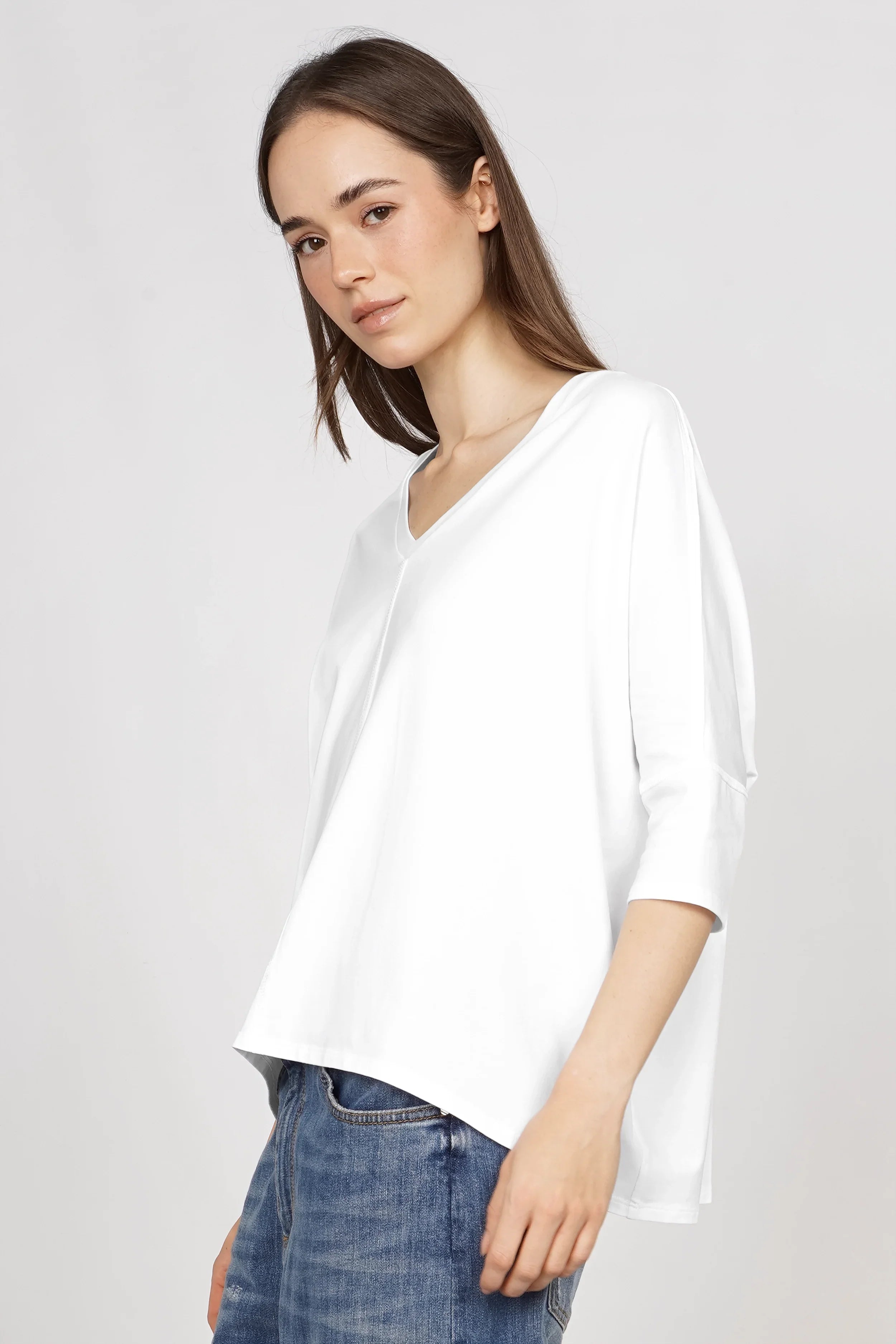 Weißes Blusenshirt mit V-Ausschnitt, lockerer Passform und kurzen Ärmeln getragen von Model