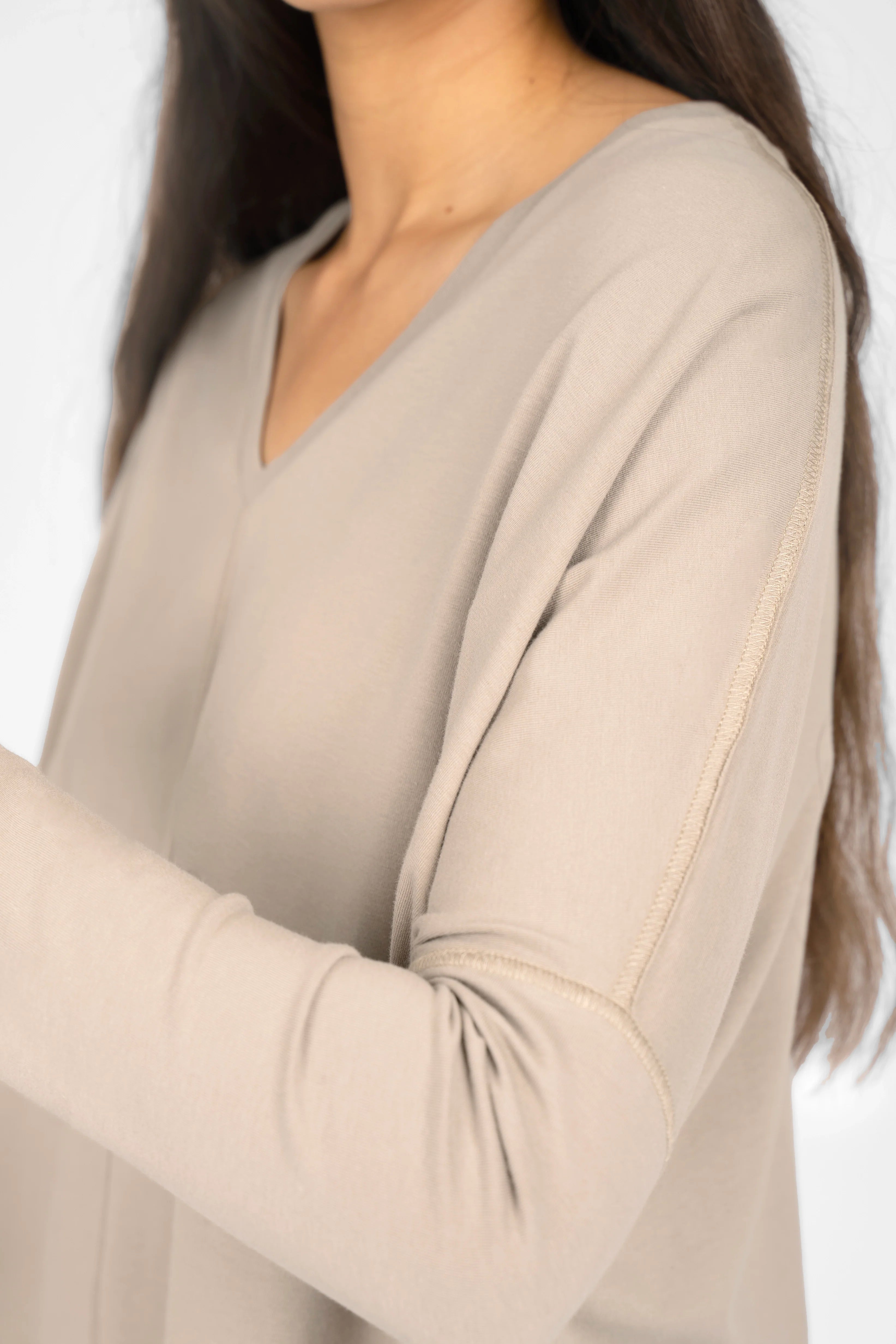 Close-up of a woman wearing beige TIDA Blusenshirt Langarm with V-neck and long sleeves in a relaxed fit