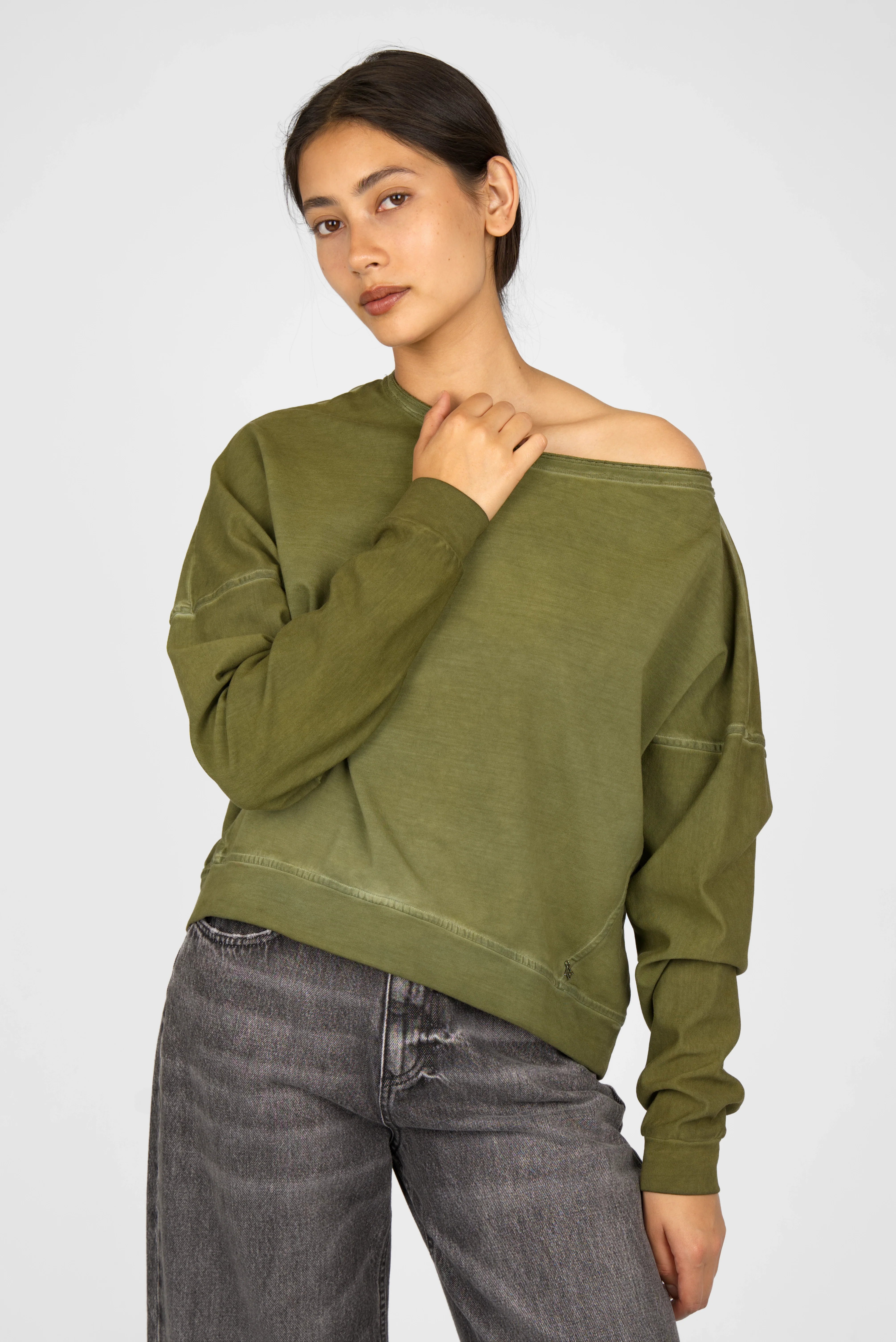 Woman wearing olive green TIMAJ Revive One Shoulder Sweater with relaxed fit and wide neckline showing one shoulder