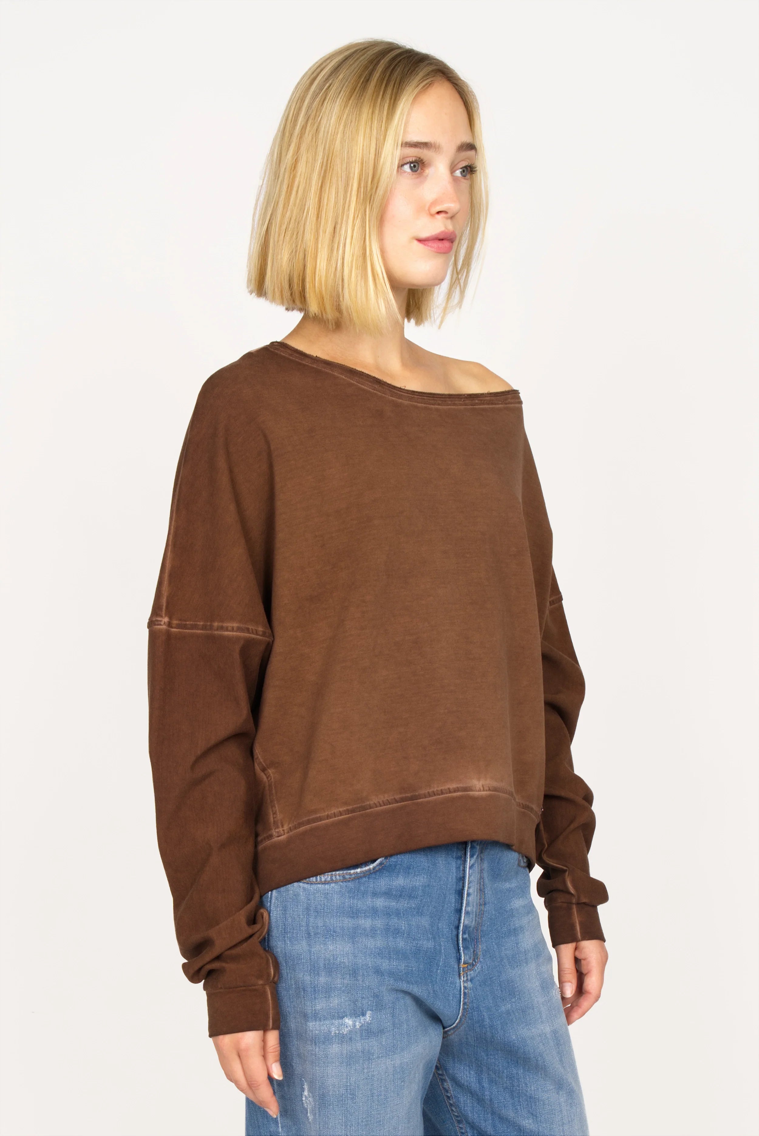 TIMAJ Revive One Shoulder Sweater in mocha vintage wash with wide raw-edge neckline and loose fit on model wearing blue jeans