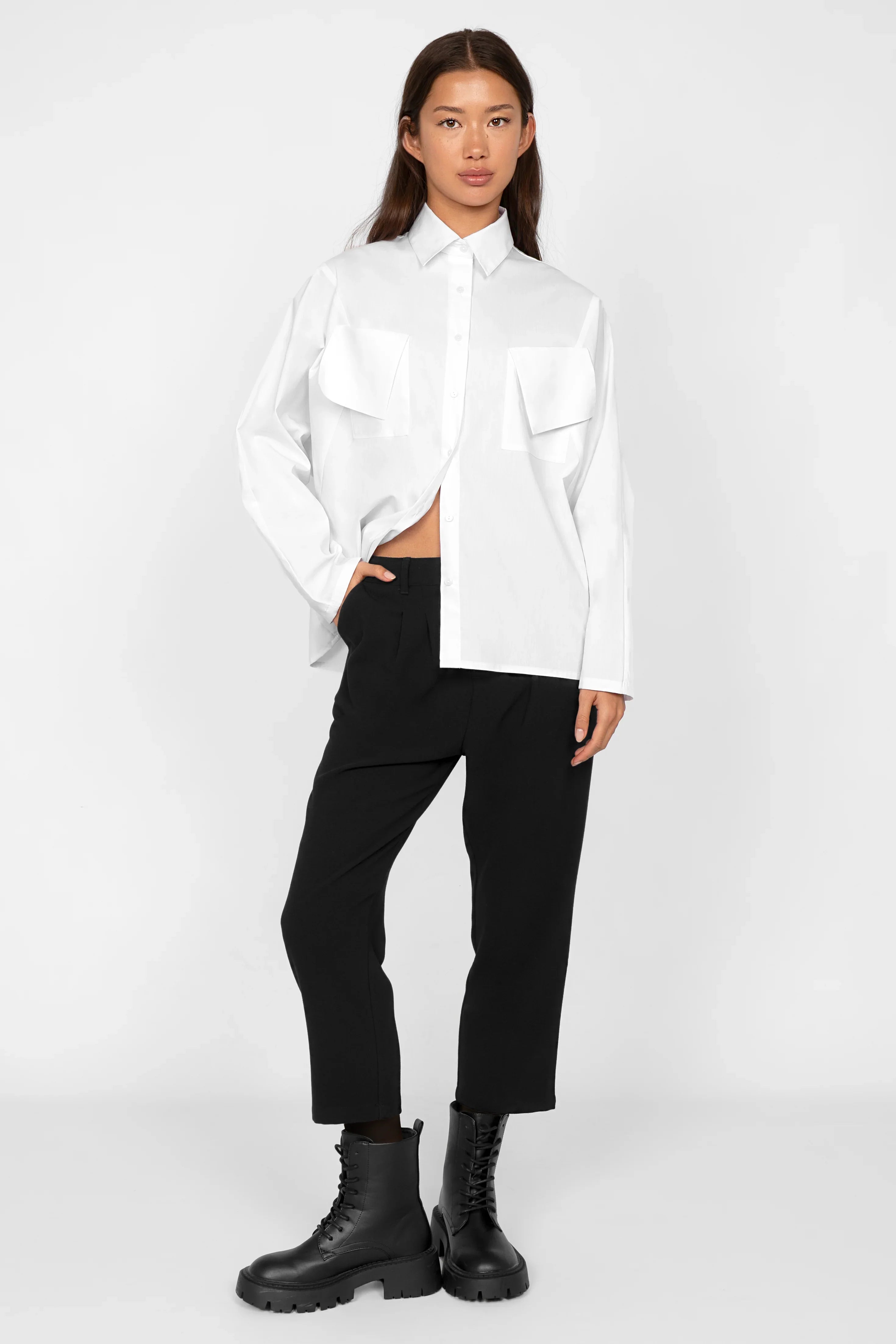Woman wearing black TINKE cropped fit pants with white shirt and black boots