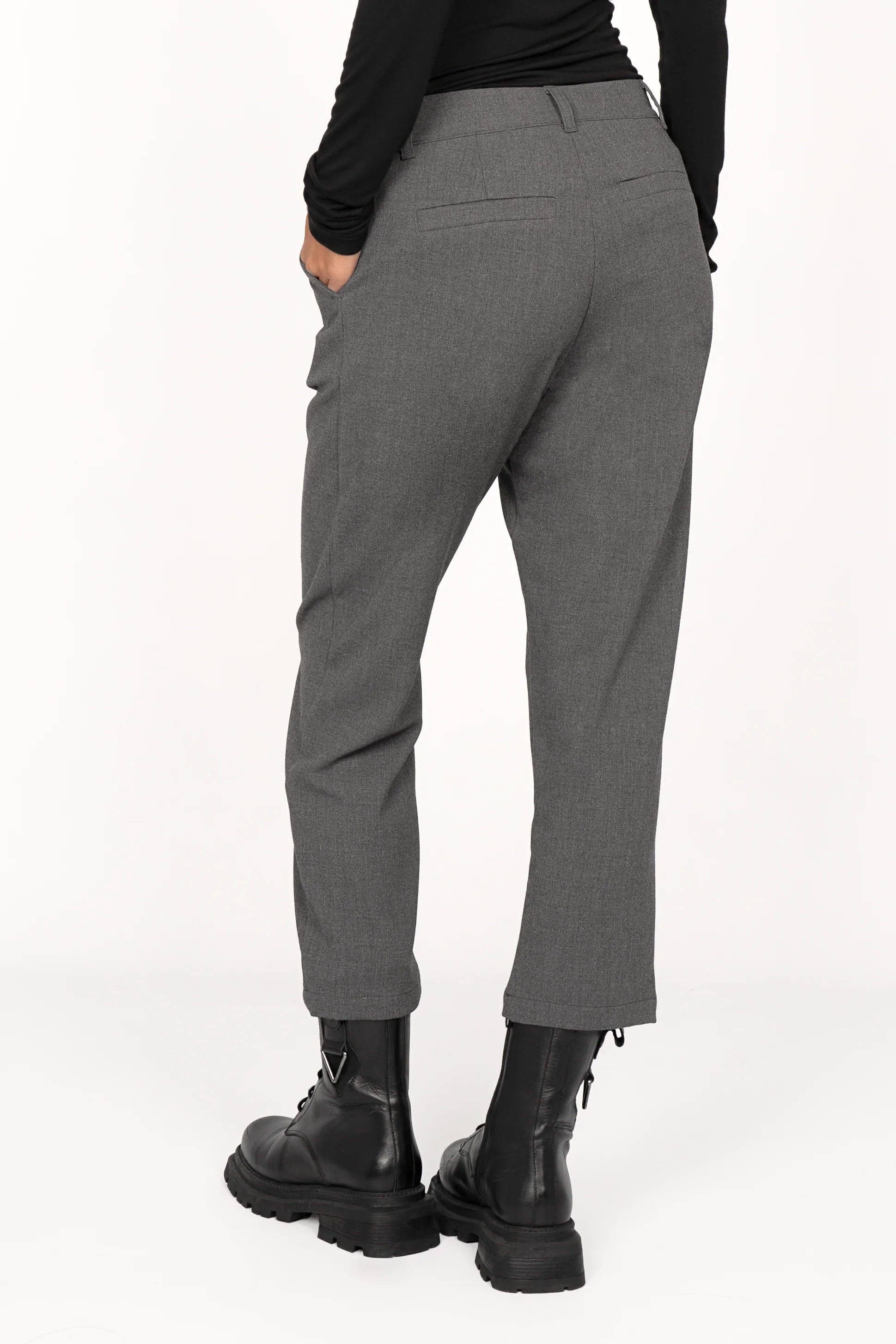 Back view of TINKE Hose Cropped fit gray pants with cropped length and slight pleats paired with black boots