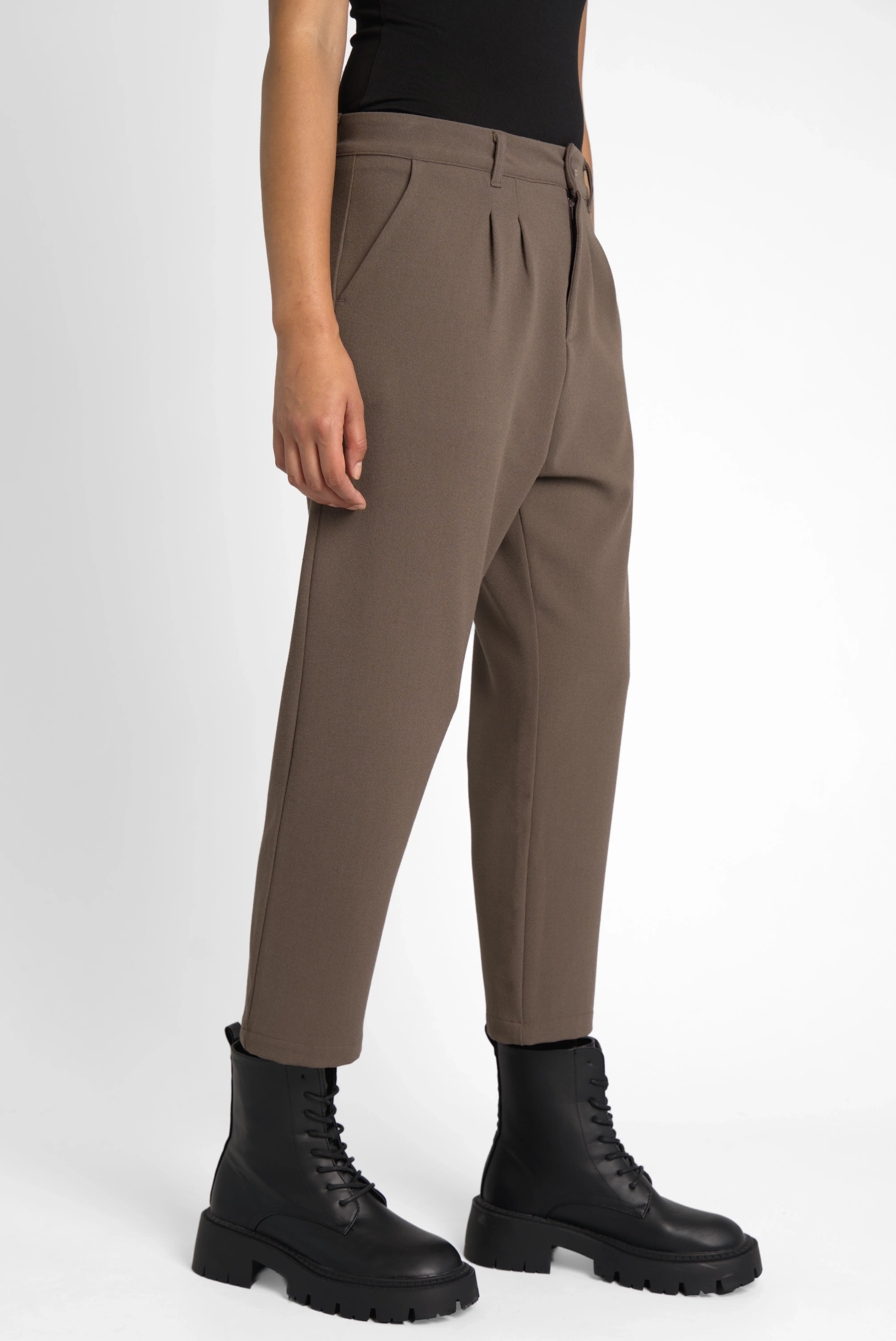 Woman wearing brown TINKE Hose Cropped fit pants with pleats and black boots