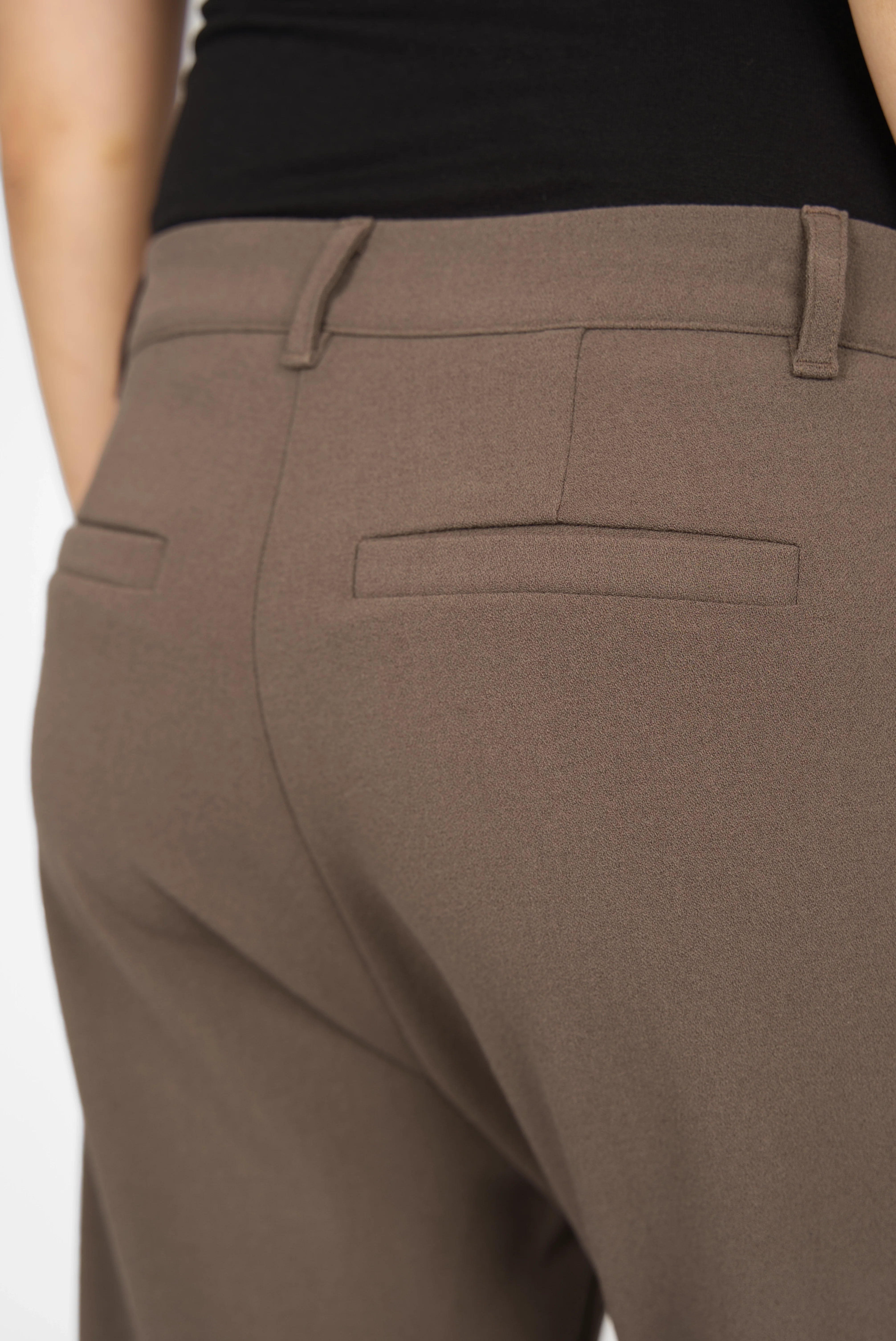 Close-up of brown cropped TINKE Hose Cropped fit pants with belt loops and back welt pockets