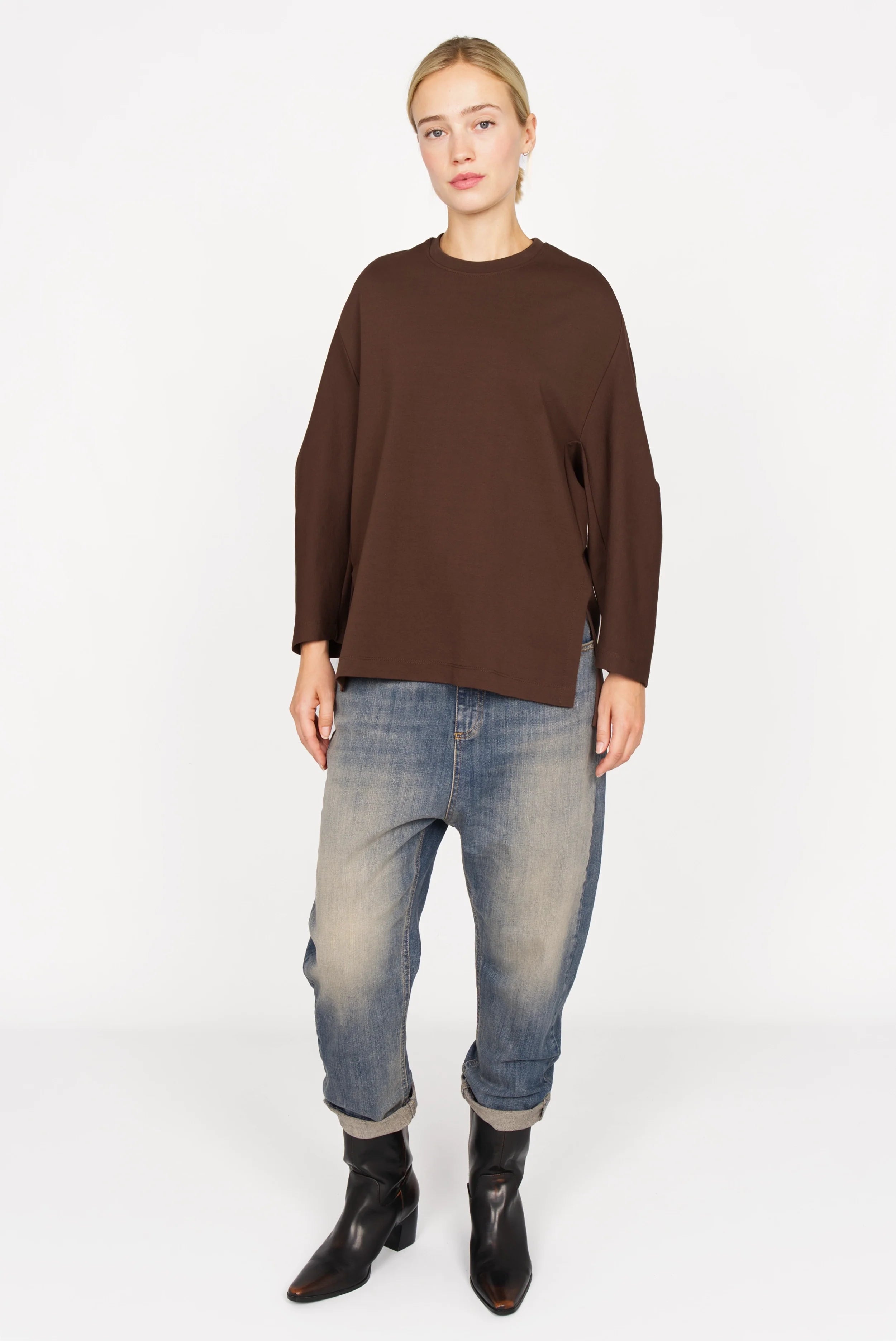 Frau trägt braunes TOOVE Shirt aus elastischem Interlock-Jersey mit Rundhalsausschnitt und seitlichen Schlitzen