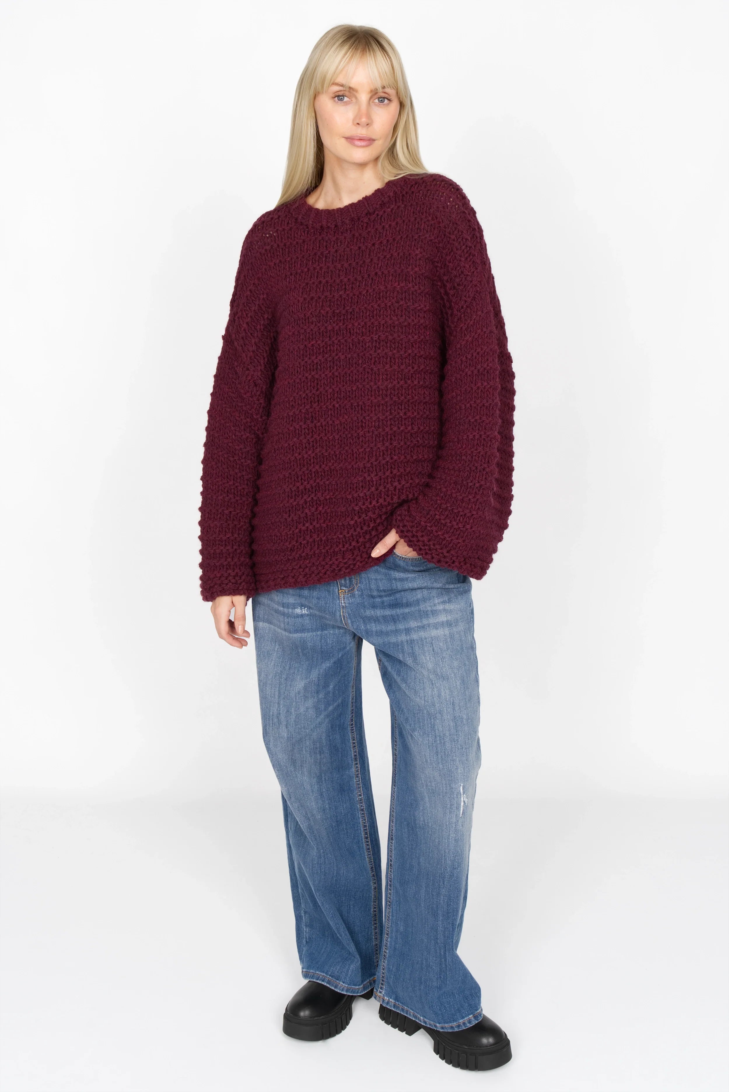 Woman wearing VAILE oversized grobstrick pullover in burgundy with round neckline and wide sleeves