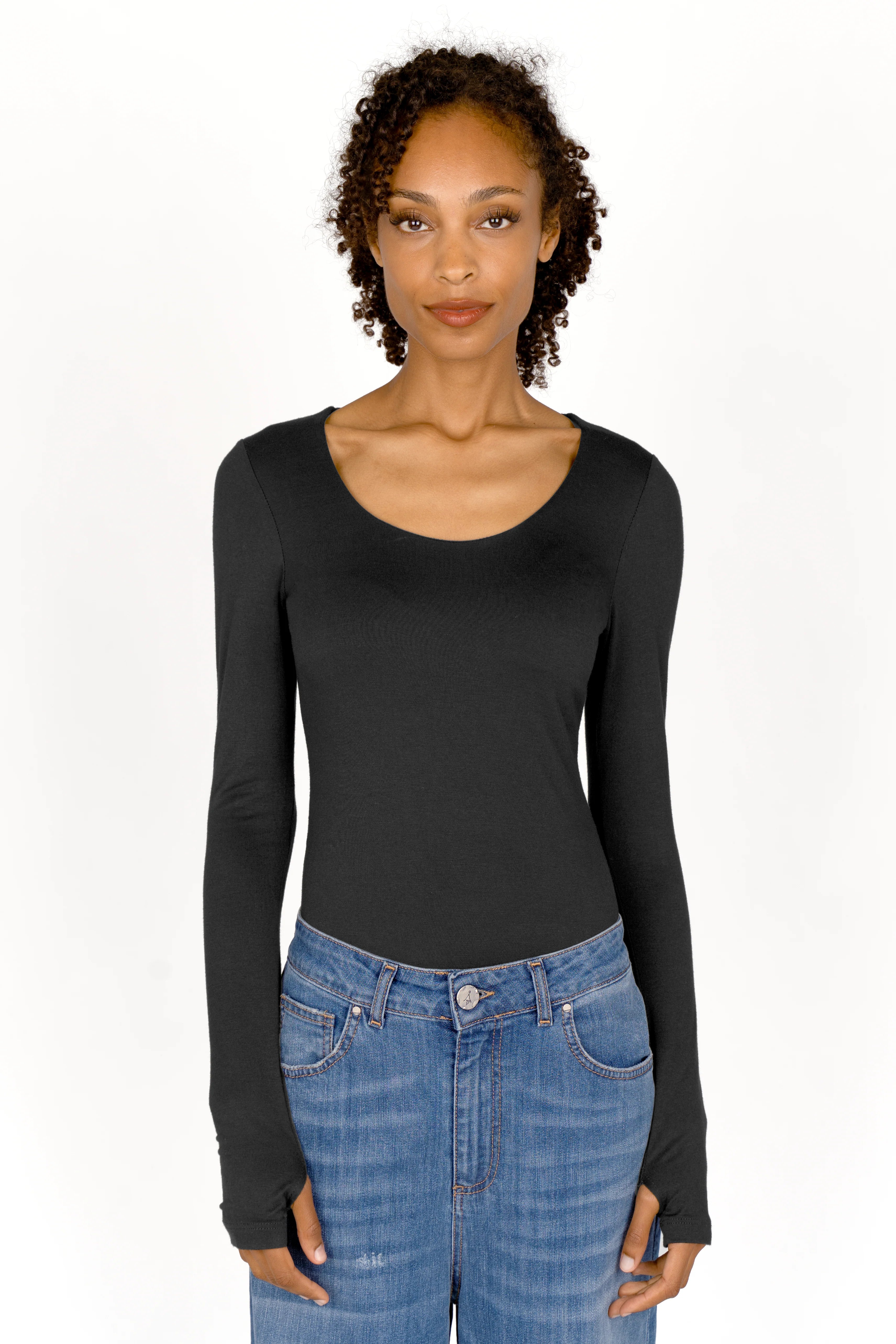 Woman wearing black VALUM Longsleeve with thumb holes and boat neckline paired with blue jeans